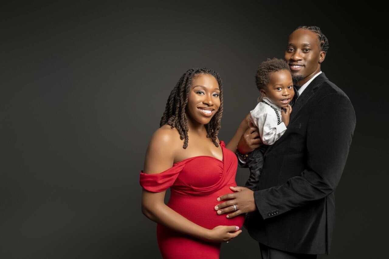 Family maternity portrait with elegant black dress and tuxedo
