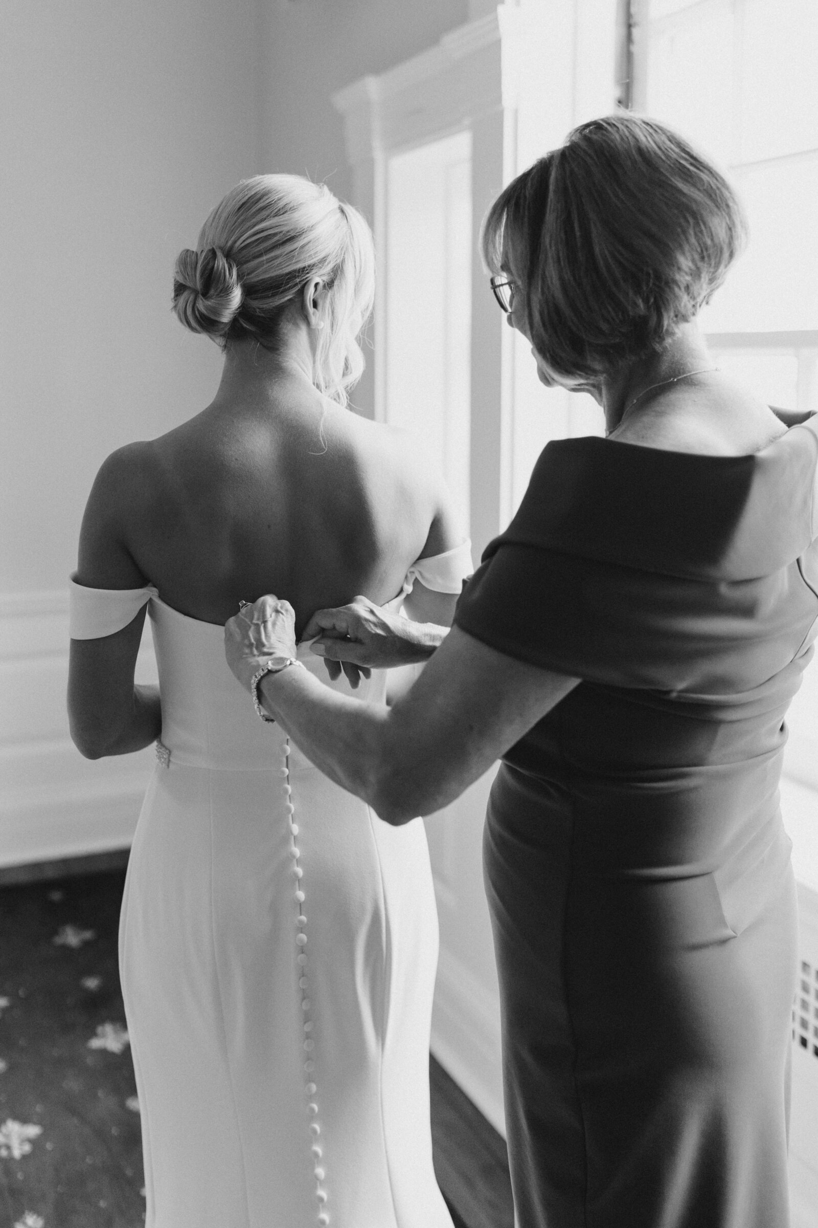 Mom helps bride into dress