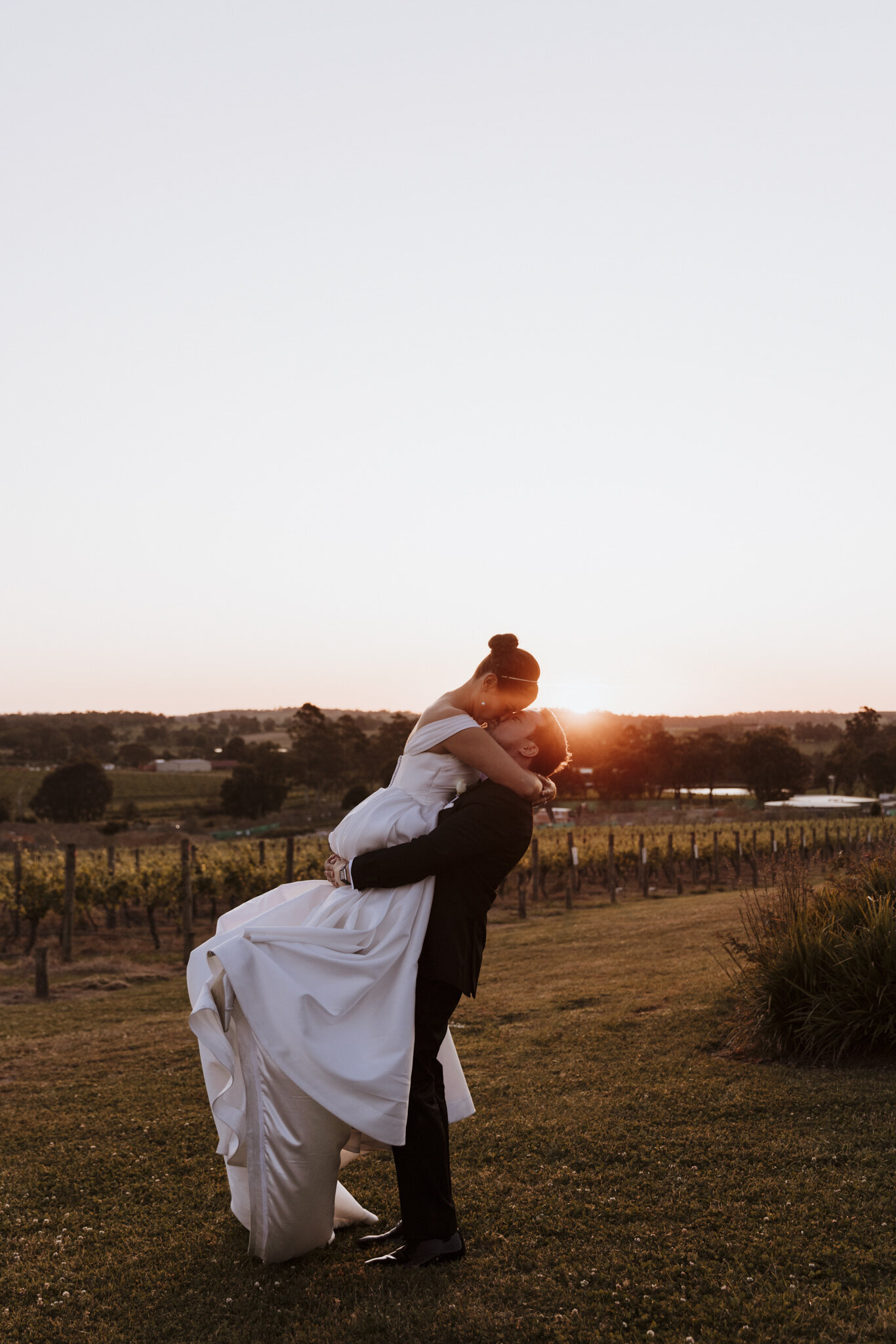 A bride and groom in front of a sunset by photographer ada and ivy