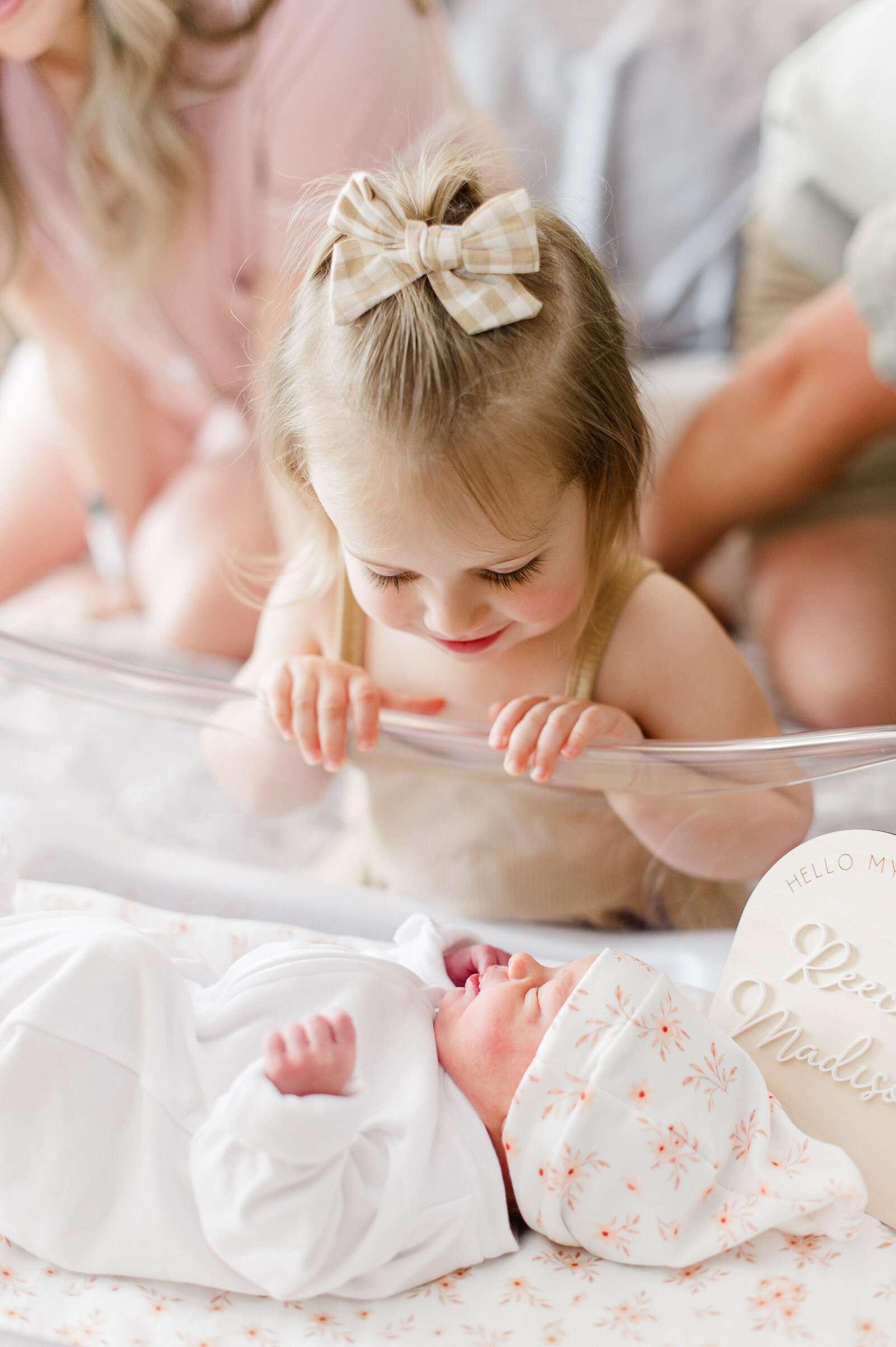 Big sister meeting and in awe of her baby sister during fresh 48 photos