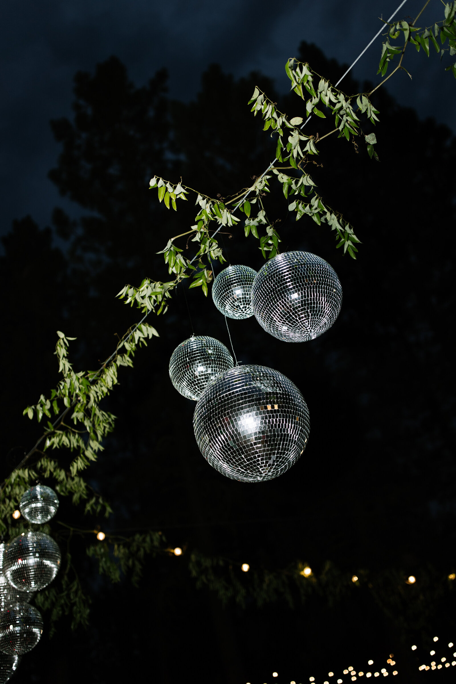 Disco balls spinning above dance floor with colorful lights at retro Lake Tahoe wedding