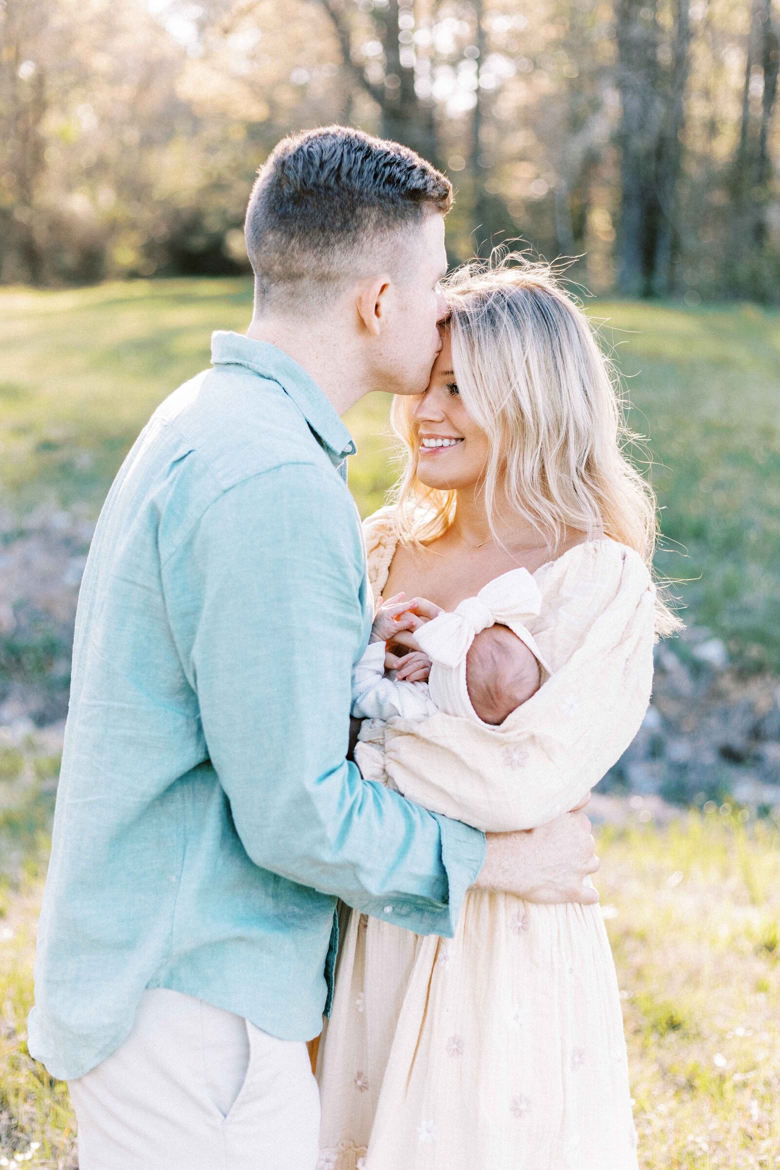 dad kissing mom's forehead in peoria illinois newborn photos 