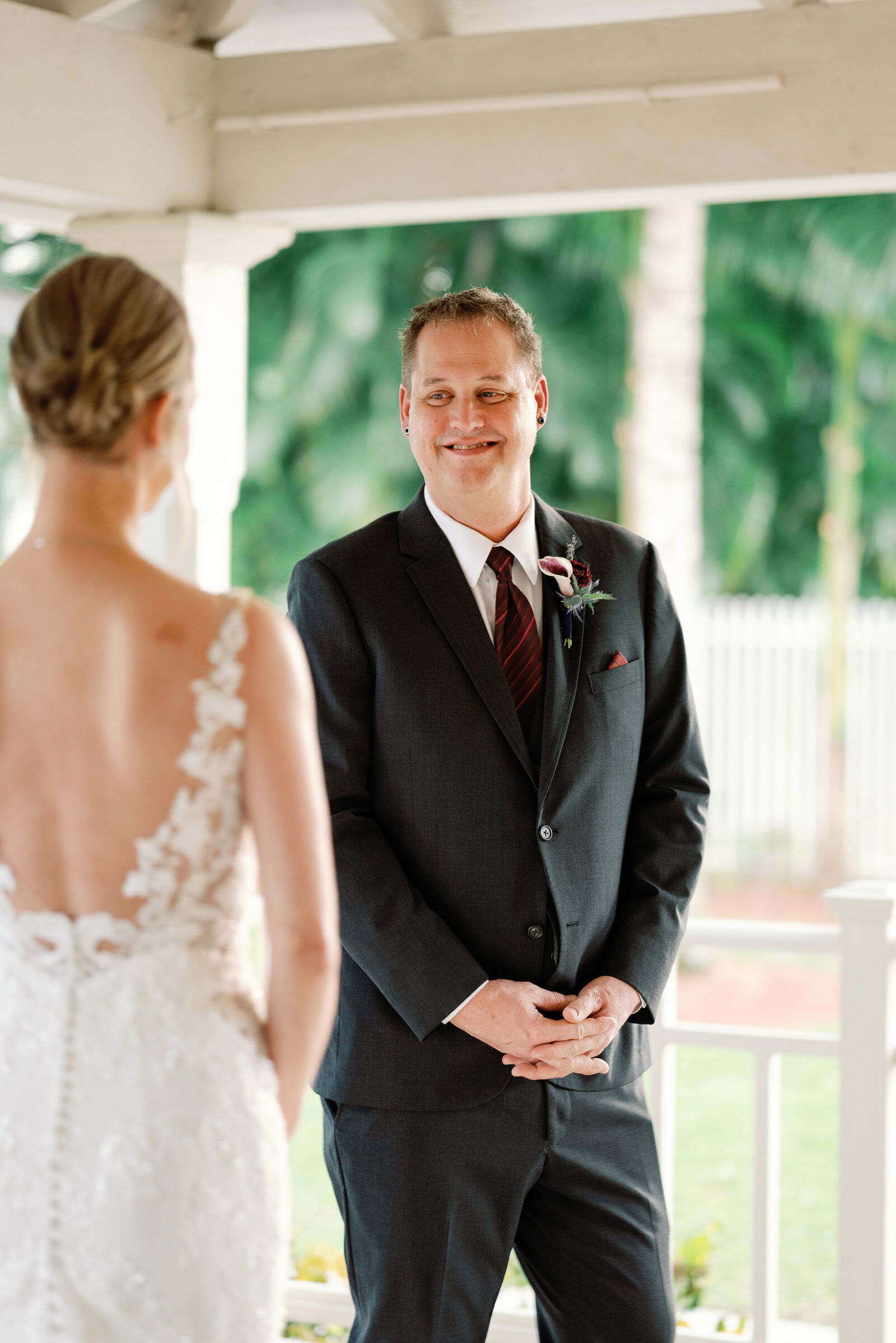 Groom smiling at his bride while seeing her during their wedding day first look