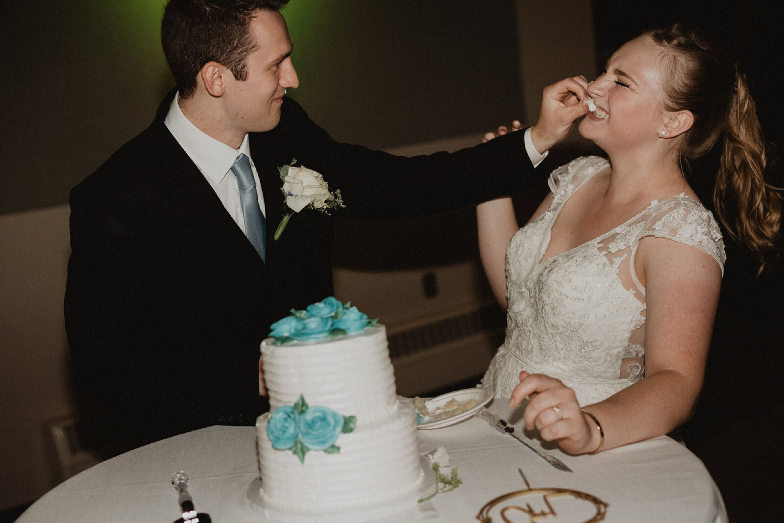 the blog - groom putting frosting on brides face