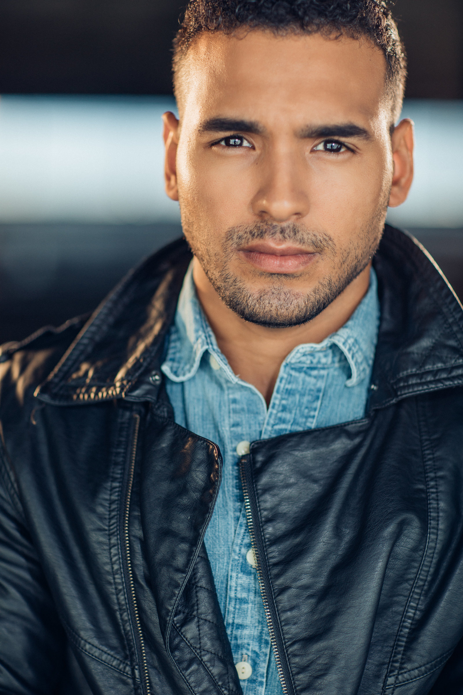 Headshot Photo Of Young Man In Black Leather Jacket And Blue Denim Polo