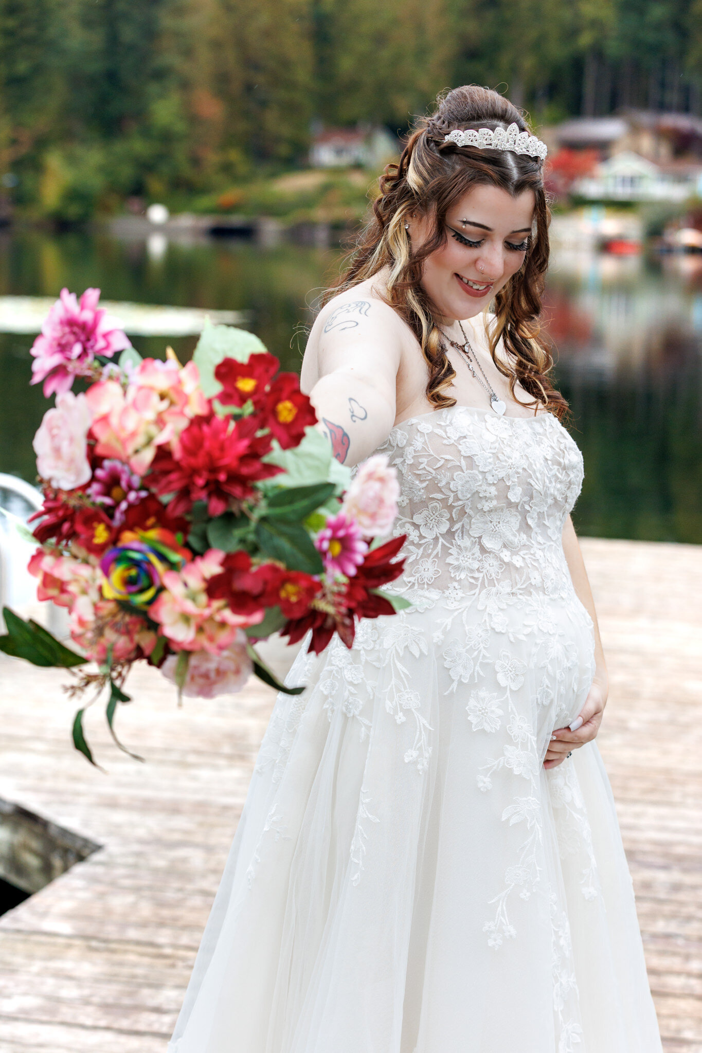 Seattle wedding portrait of a pregnant bride during a beautiful day standing on a lake dock holding her gorgeous bouquet of flowers.
