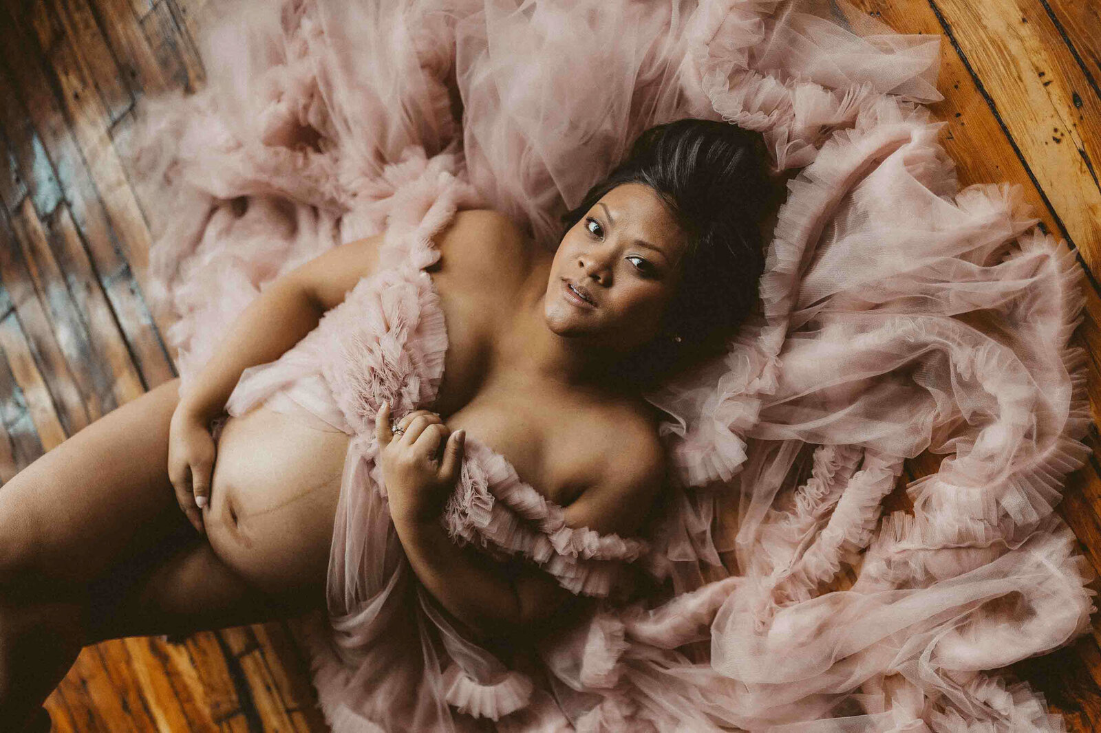 portrait of a pregnant woman laying on the floor