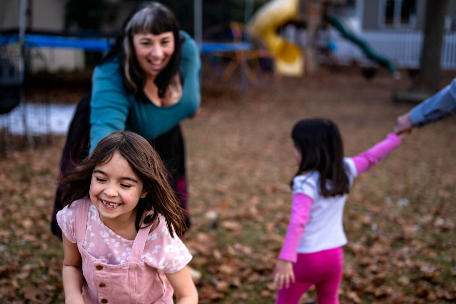 Mom plays red rover with kids at family photo session
