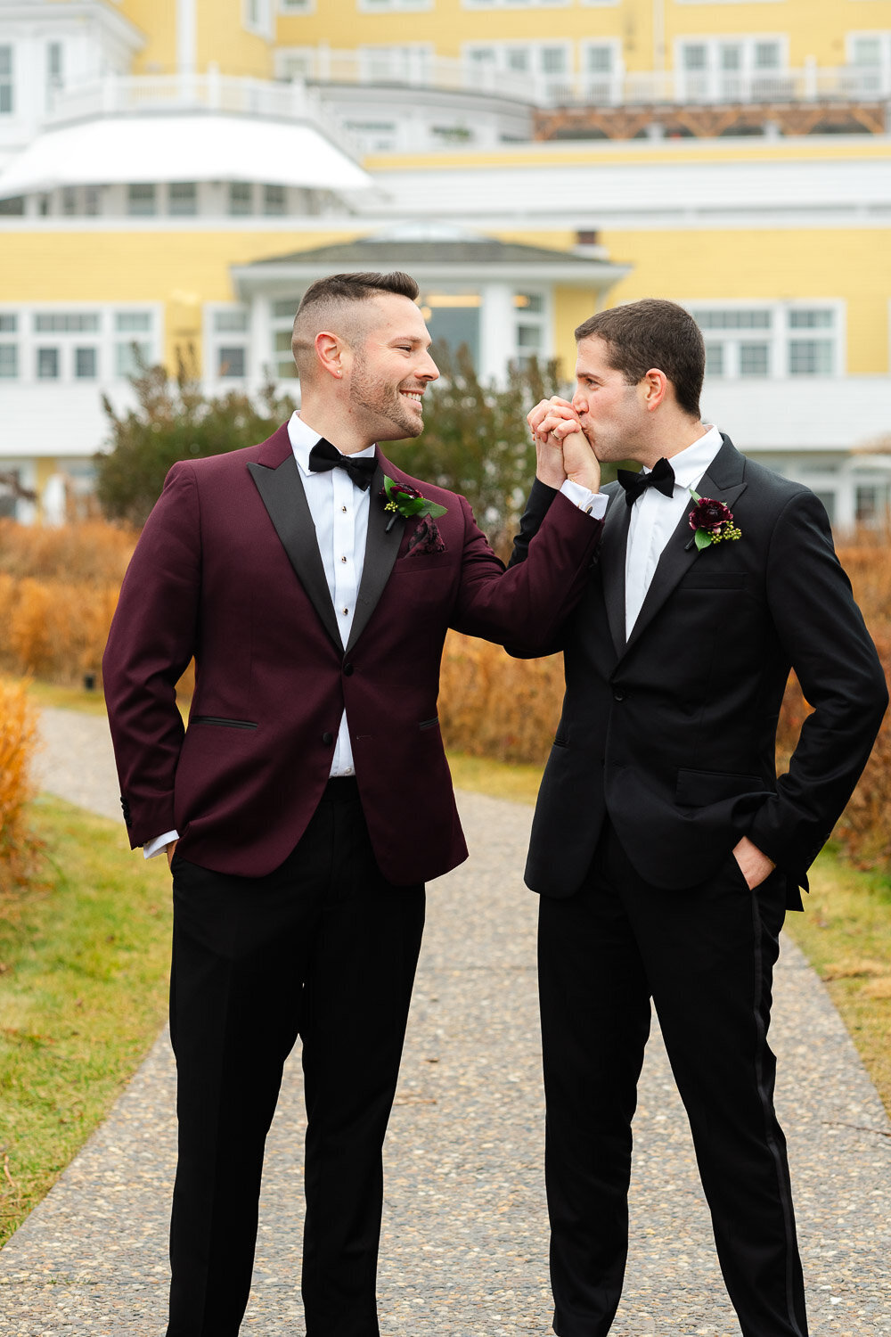 groom kisses grooms hand at Ocean House