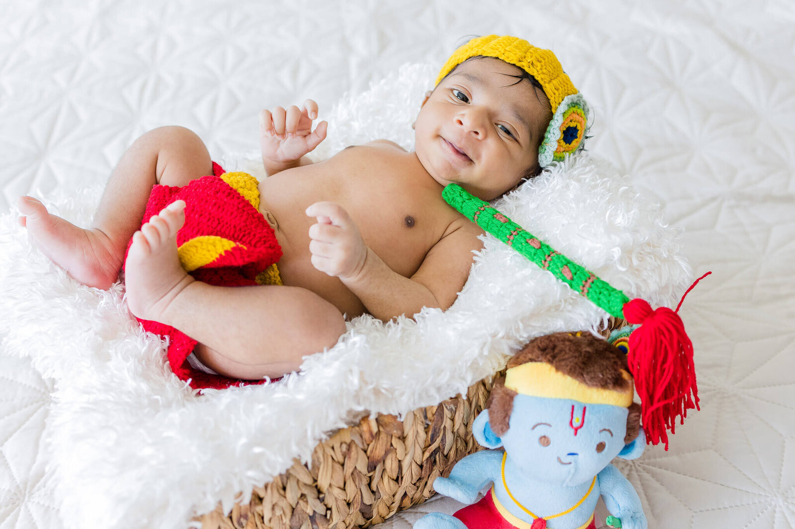 A newborn boy in a Krishna outfit.