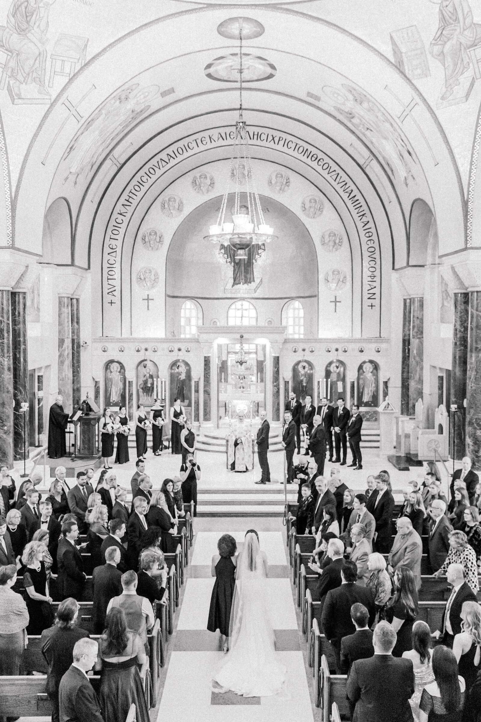 Bride walking down the aisle to the groom in a beautiful Greek Orthodox Cathedral