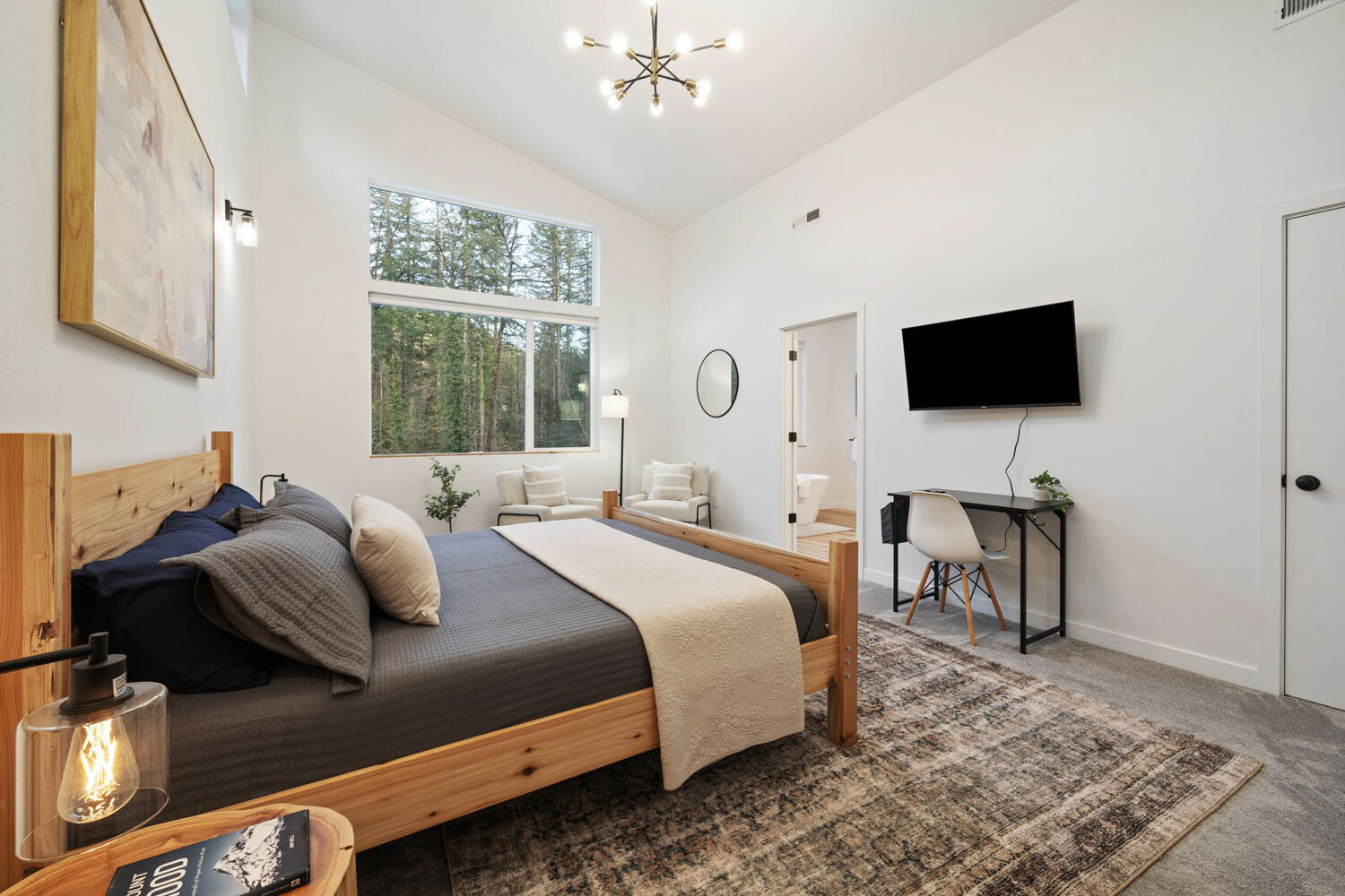 A cozy modern bedroom with a grey upholstered bed and wooden side tables