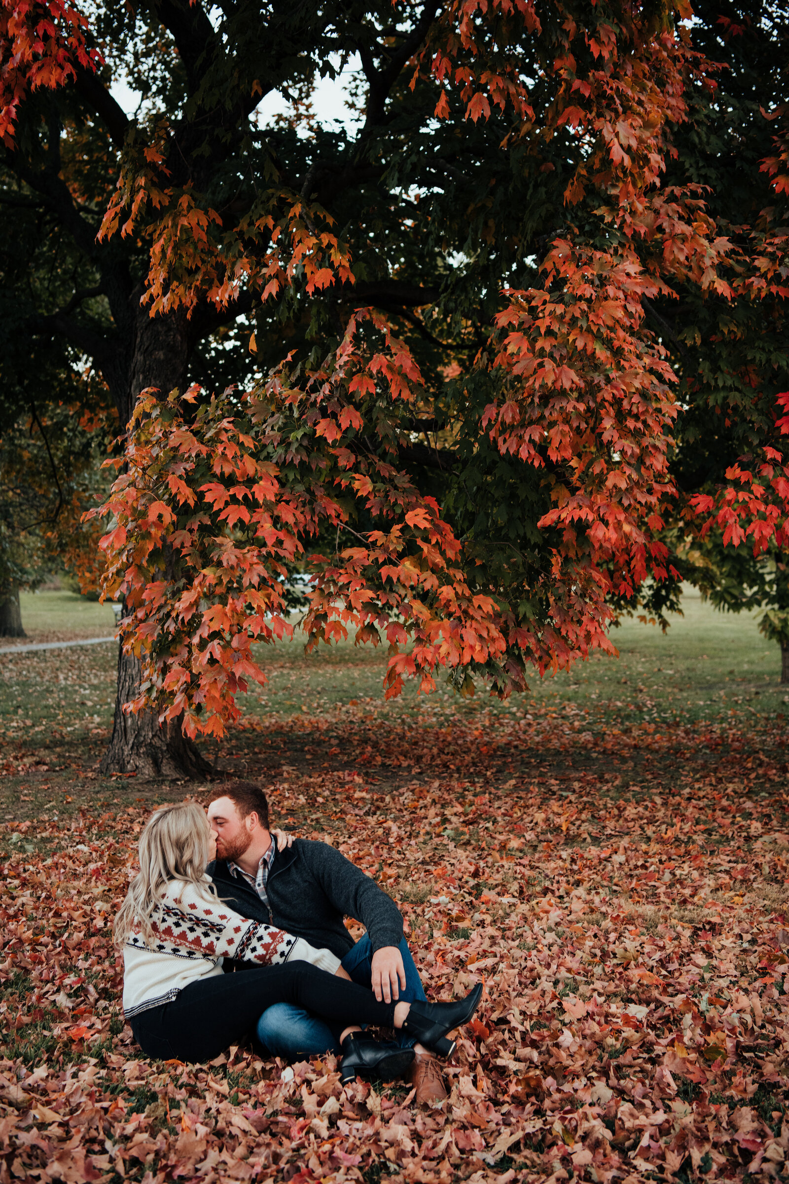 Couple kissing under fall leaves