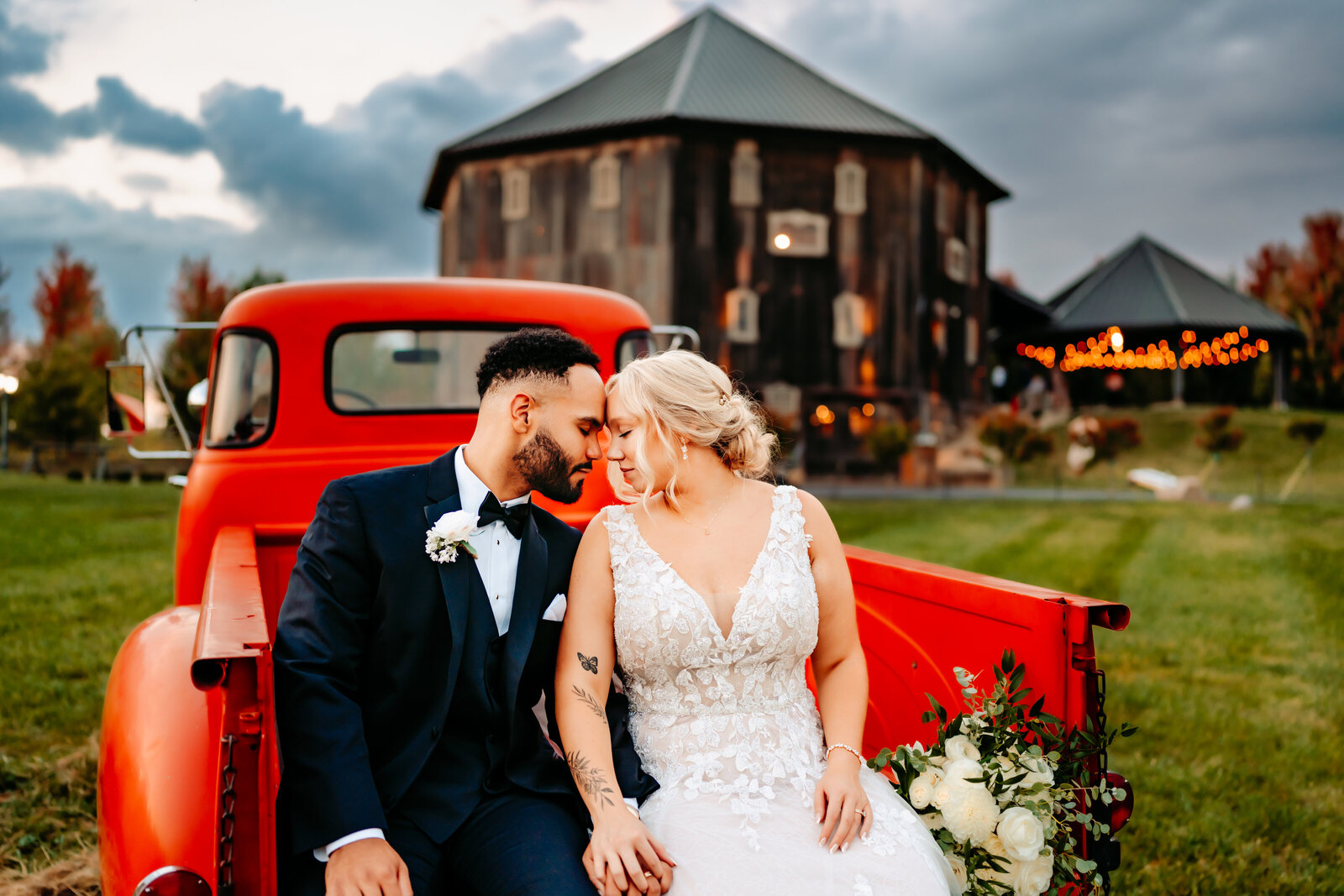 Wedding Bride and groom sitting in vintage red truck at wedding venue in central ohio\