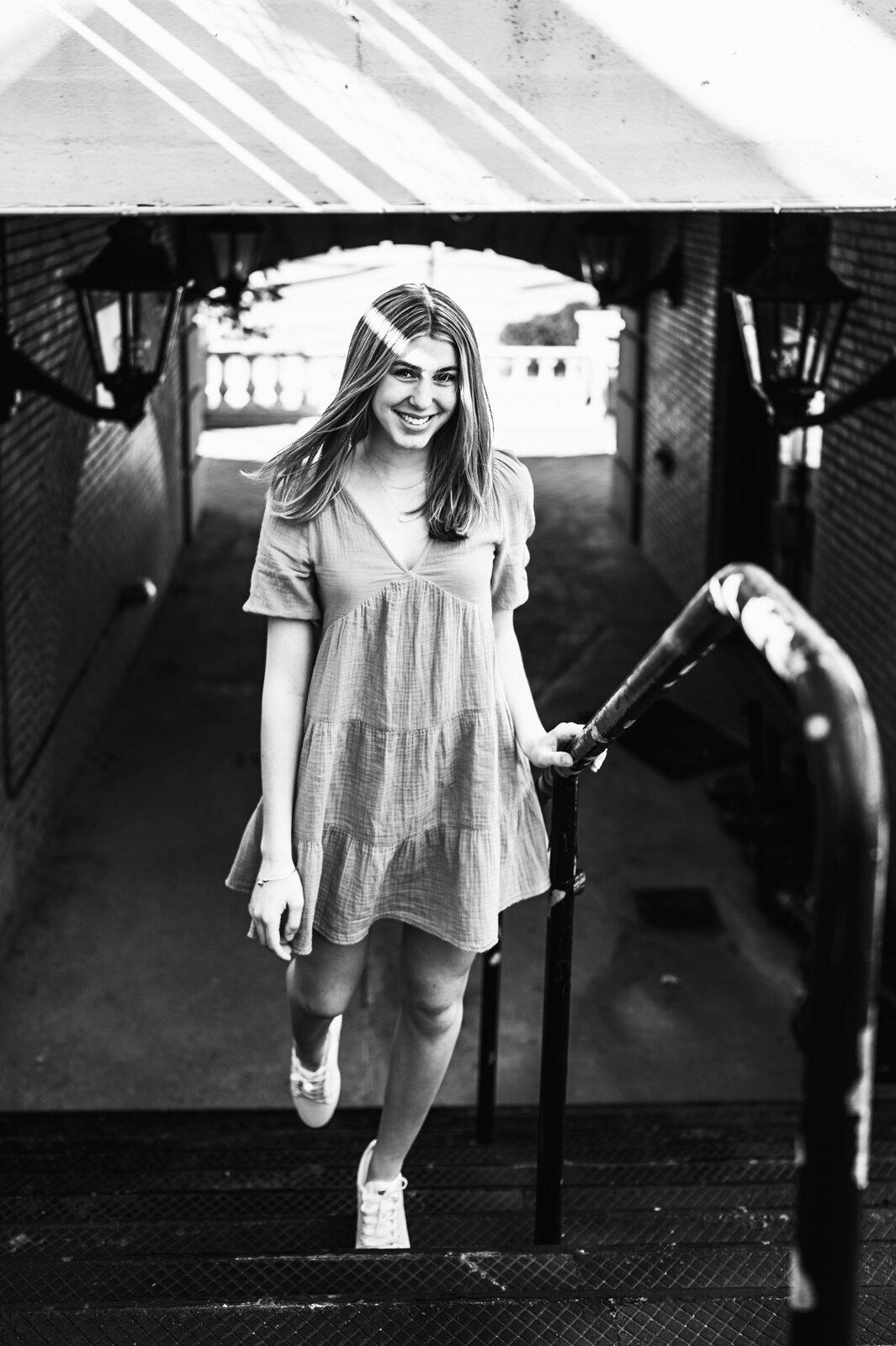 Girl walking up the stairs in a train station for her boston senior pictures