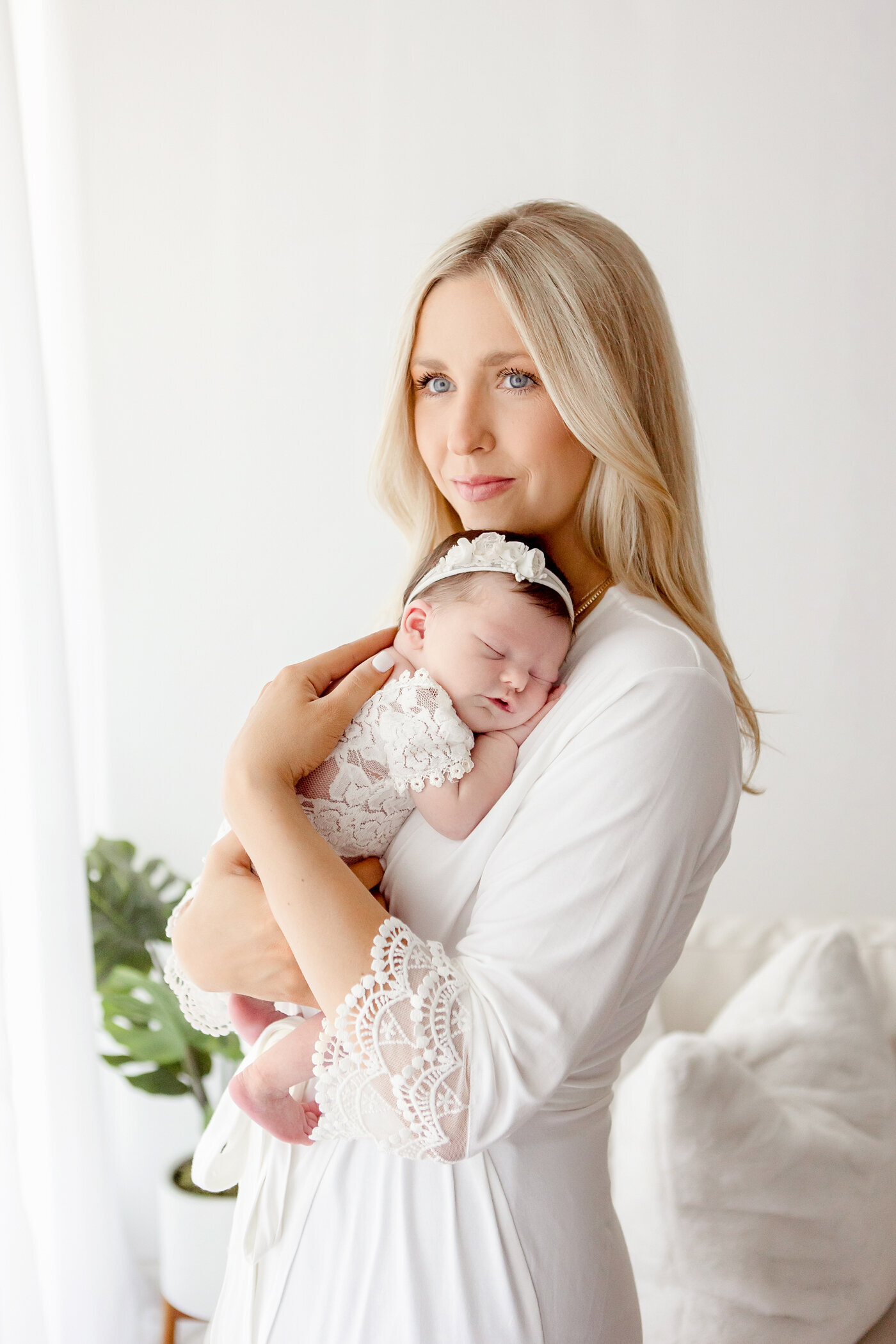 New mom hold newborn baby girl in arms, lifestyle session, light, airy photo, fresno, clovis, one good shot photography