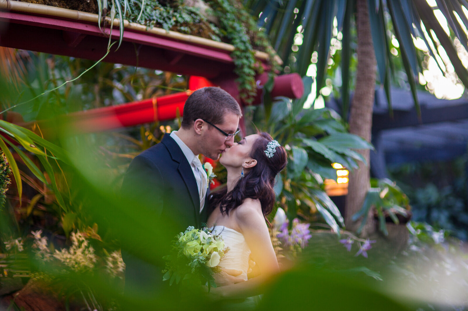 Bride and Groom sneaking a kiss at Muttart Conservatory