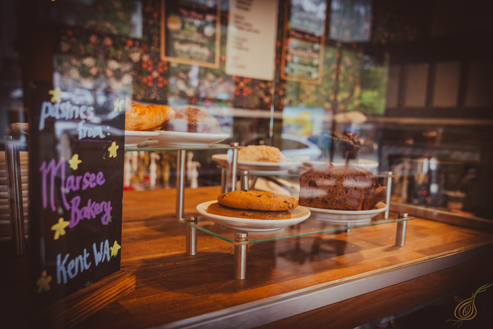 A display case featuring a prominent sign, showcasing baked pastries within for public viewing and engagement.