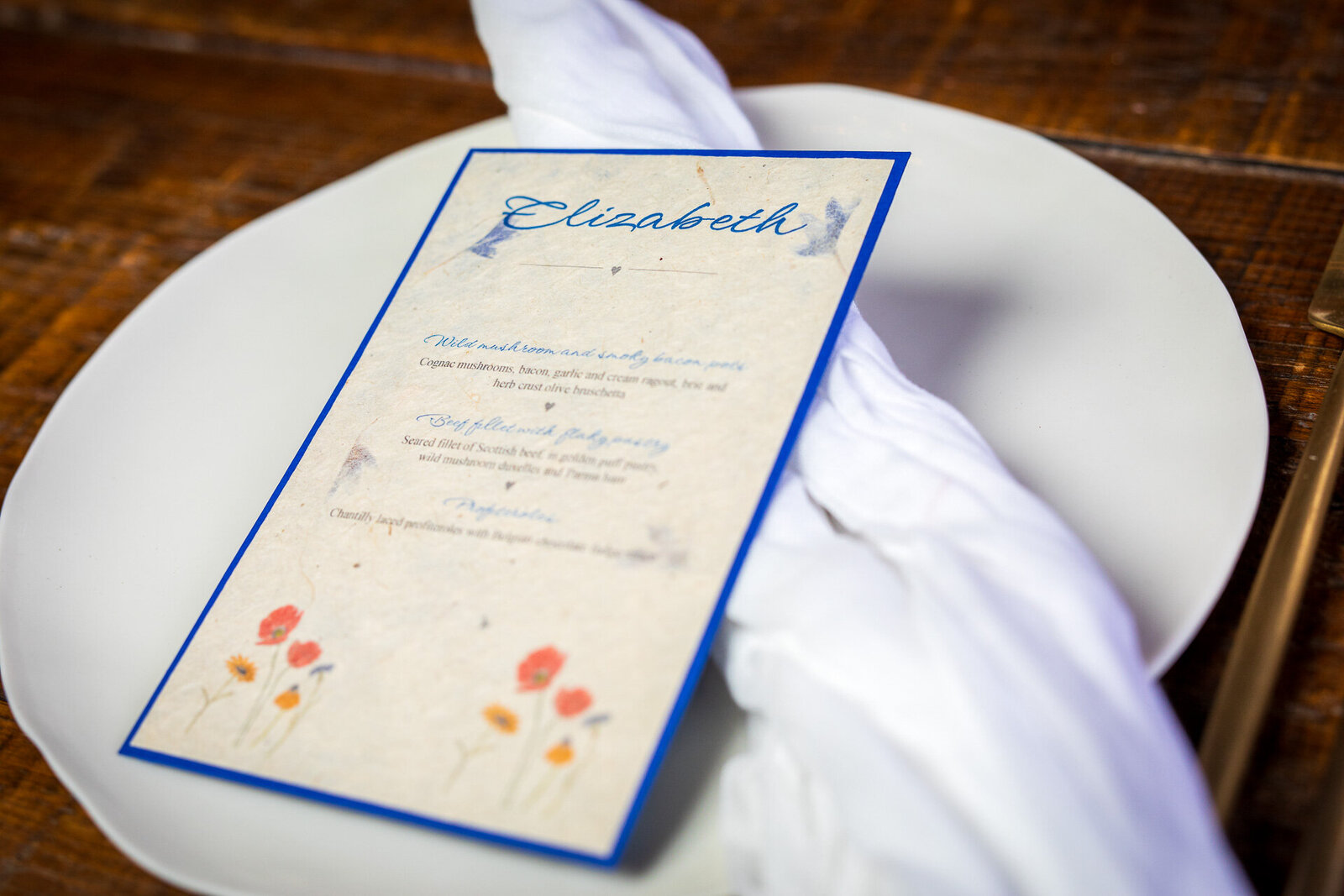 Wedding place card on sustainable lokta paper with embedded cornflower petals