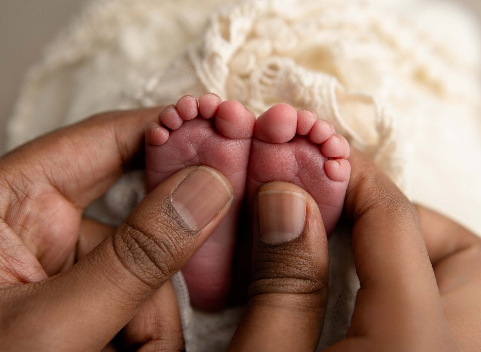 Macro photo of Dad holding newborn baby's feet. Photographed by Jenni Nikki Photography at Marietta Newborn Photo Studio.