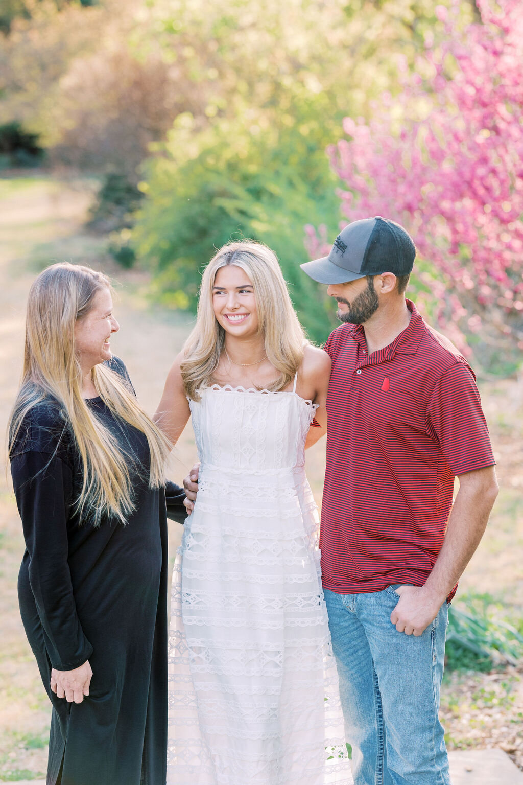 Girl smiles with parents at Athens botanical gardens