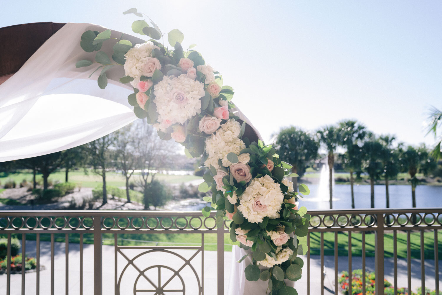 Ceremony setup with floral arch on a terrace with water views