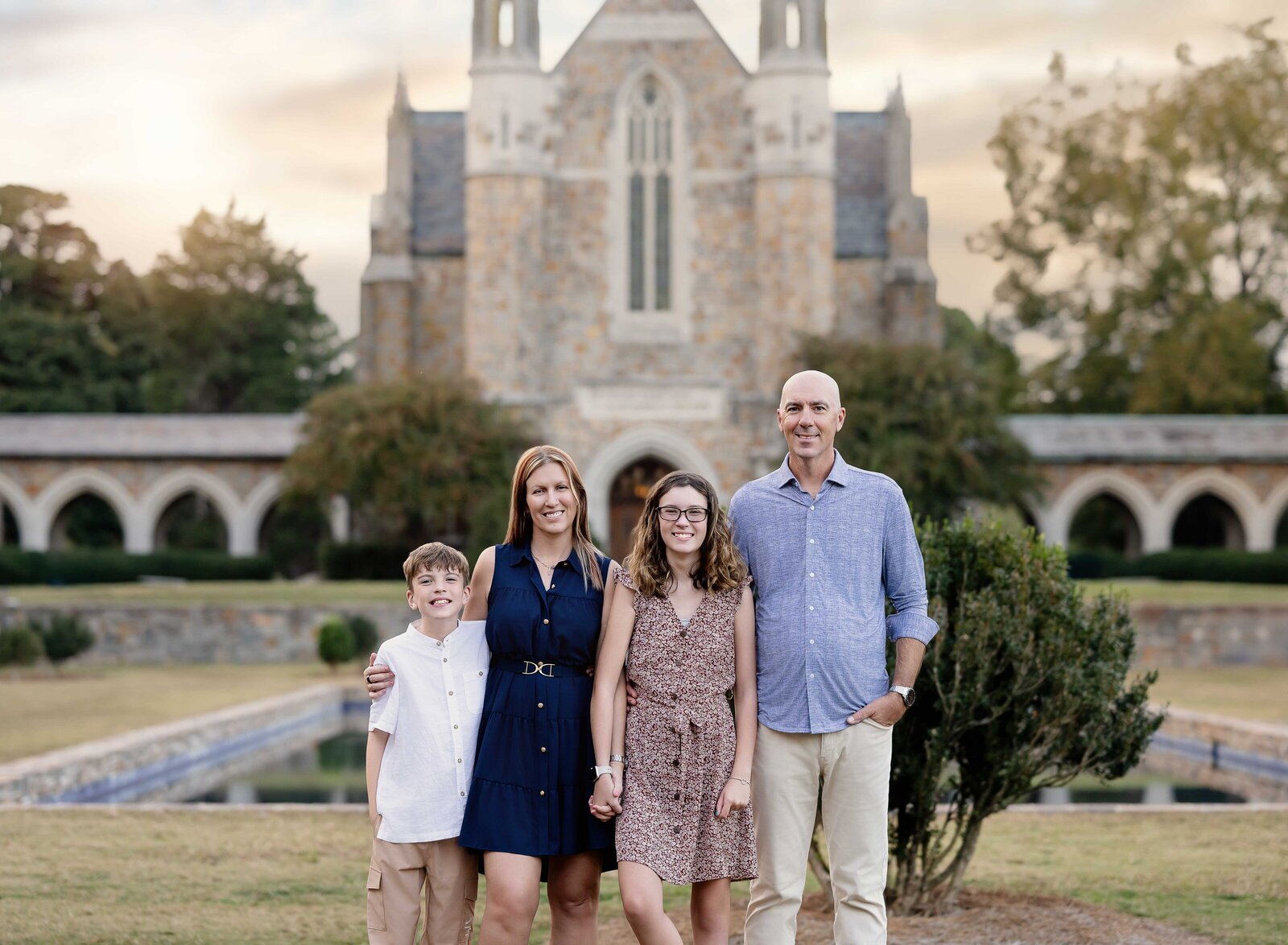 Family of 4 posing for a family photoshoot by pond at Berry College campus. Family Photography by Jenni Nikki Photography- Atlanta Family Photographer.