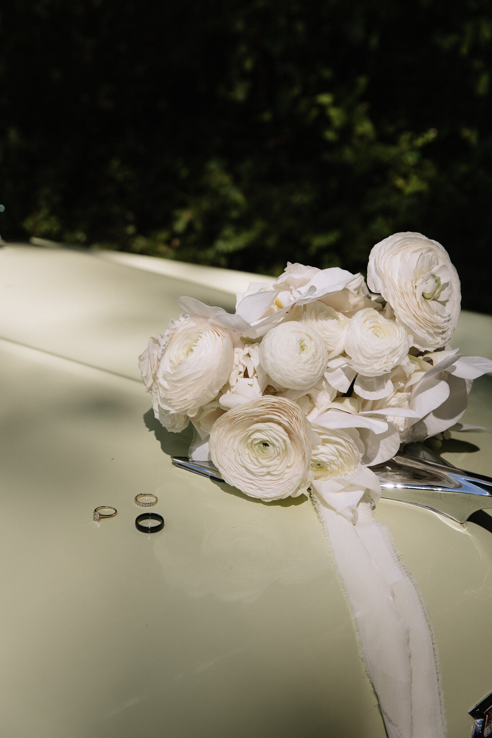 Wedding rings placed on hood of vintage car for styled elopement detail shot in Washington