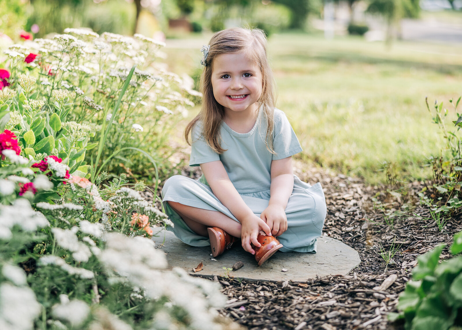 Lifestyle portrait of a young smiling girl in a garden
