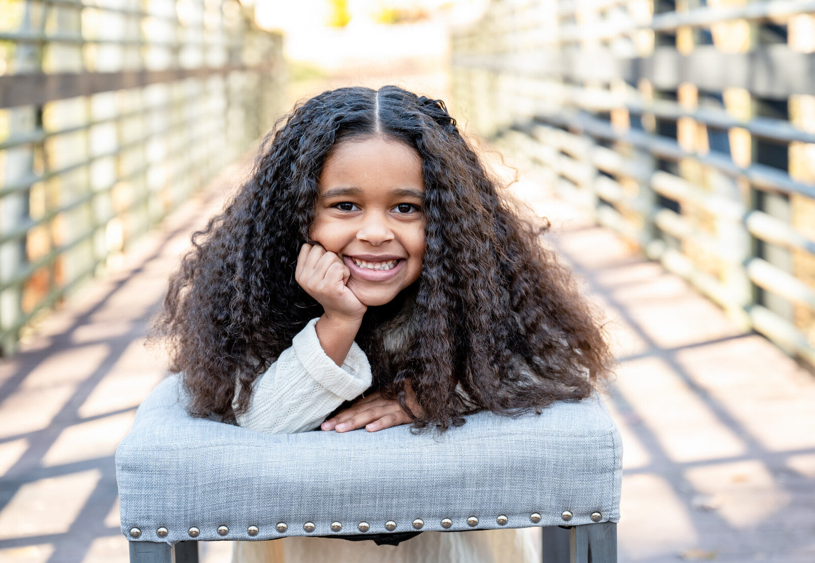 young girl posing for a photo with her head in her hand leaning on a table photographed by Millz Photography in Greenville, SC