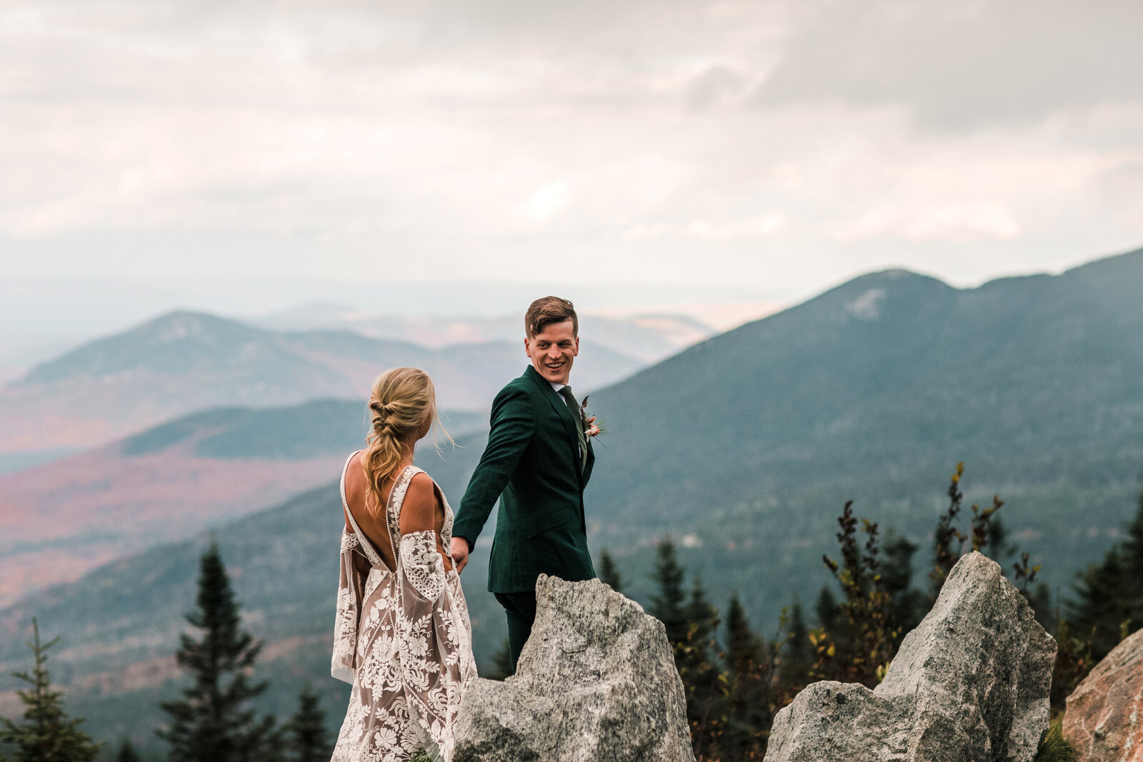 bride and groom holding hands and walking in the mountains