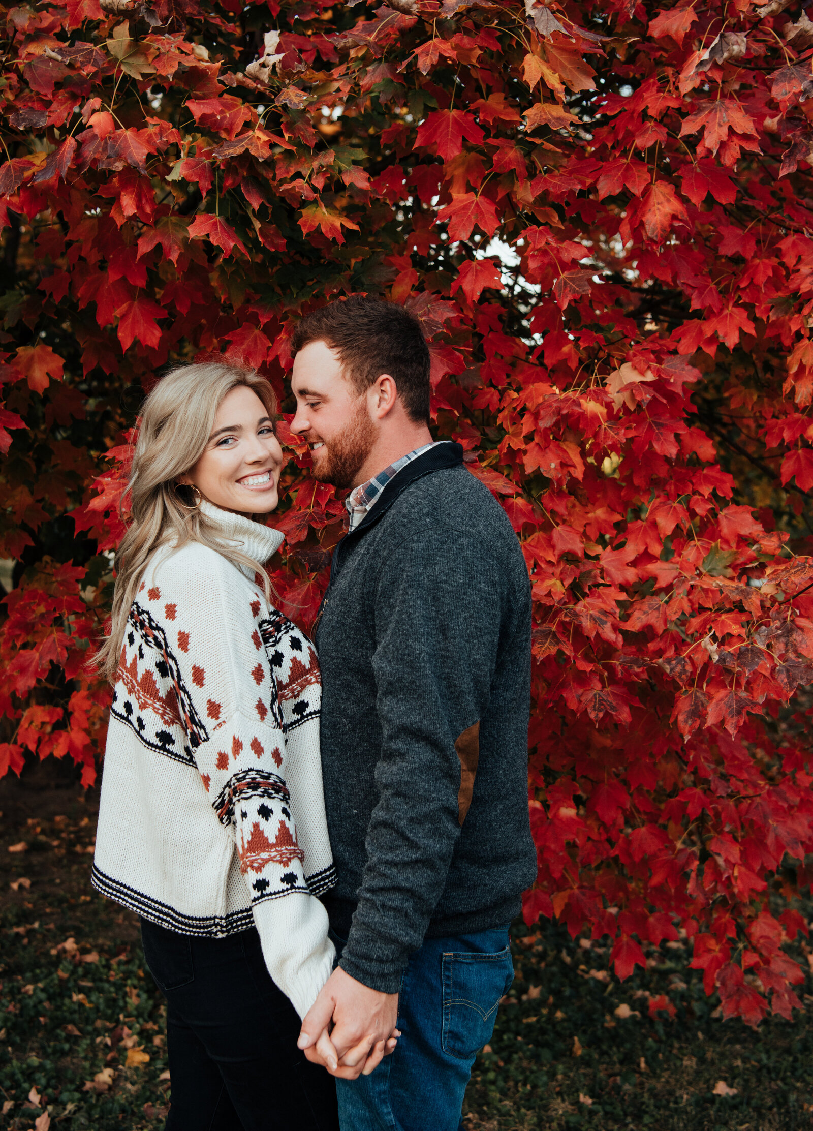 Couple to be married standing infront of autumn leaves
