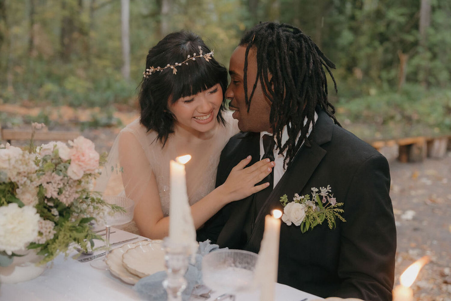 Bride and groom sharing a romantic moment at their wedding table