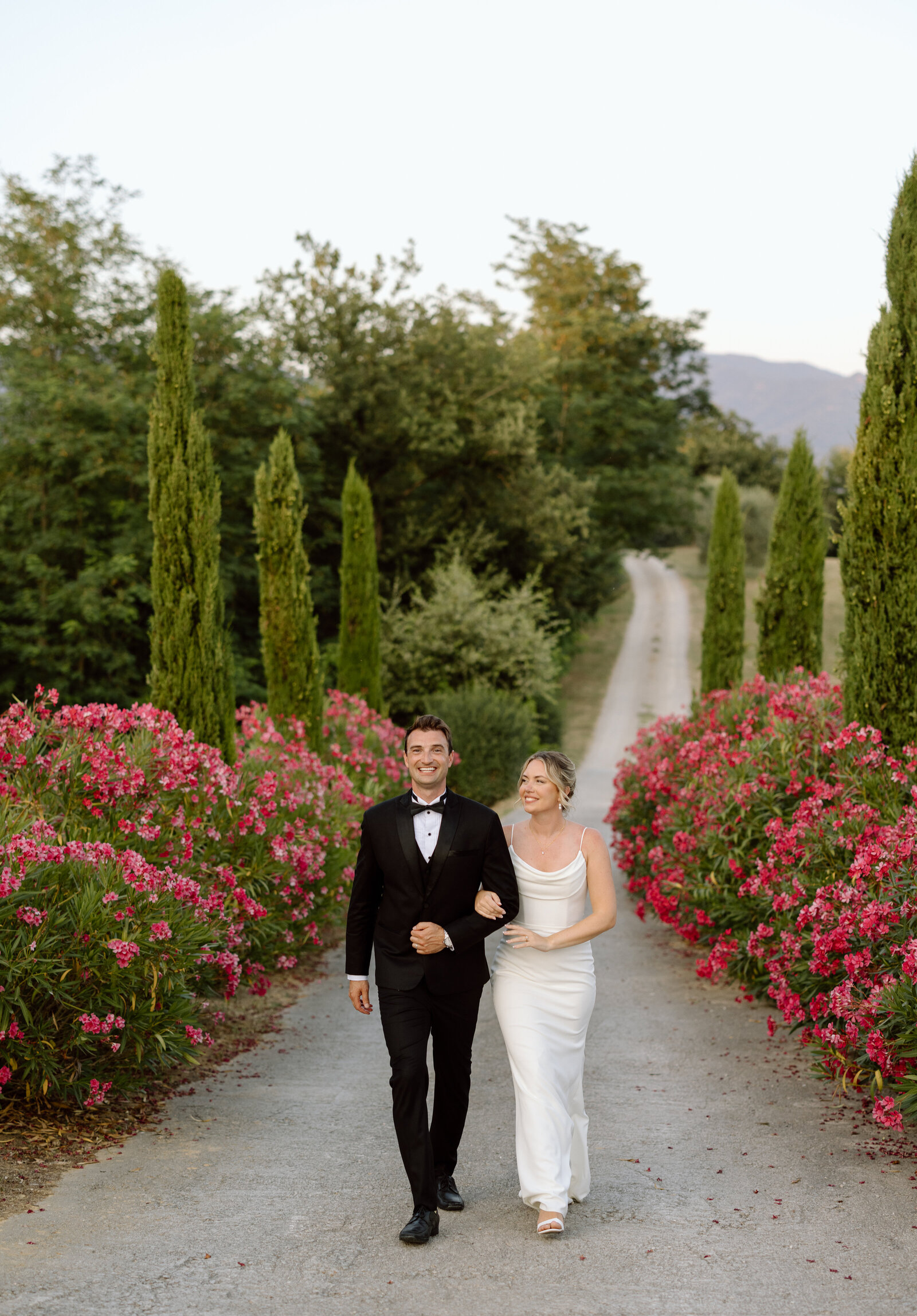 A couple walking up the road at a villa in Tuscany, Italy.