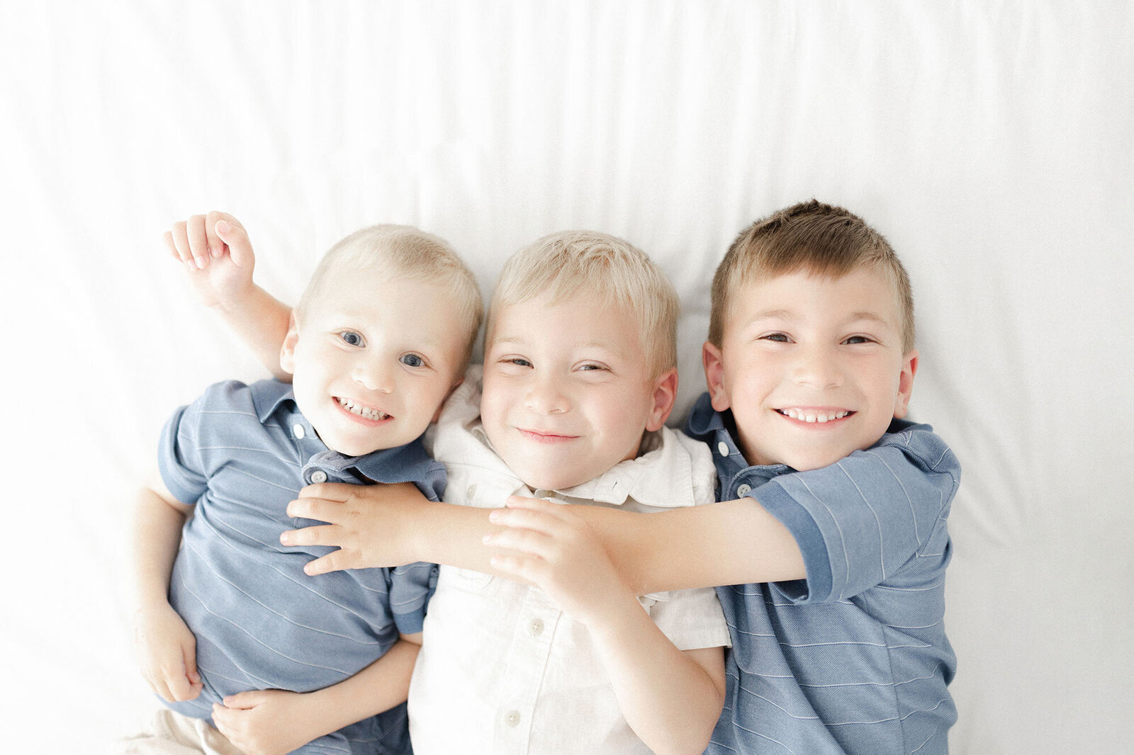 Natural light family photography of a 3 brothers smiling at the camera with Chelsea Nichole Photography