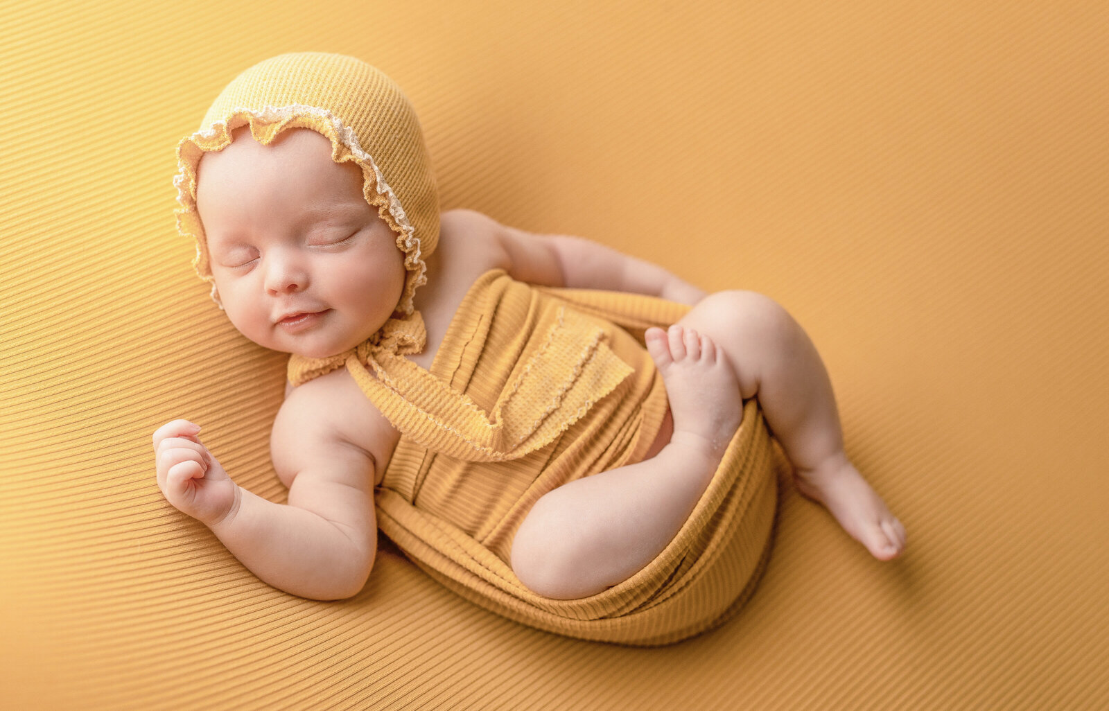 baby girl in all yellow for her newborn session