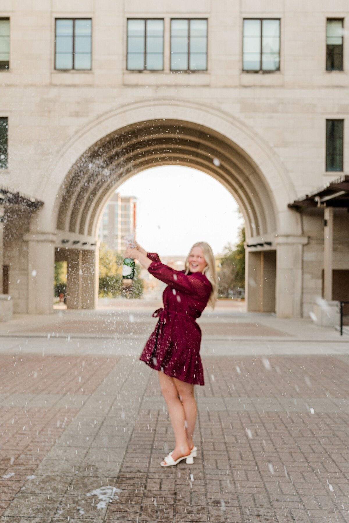 Texas state grad champagne pop at the arch