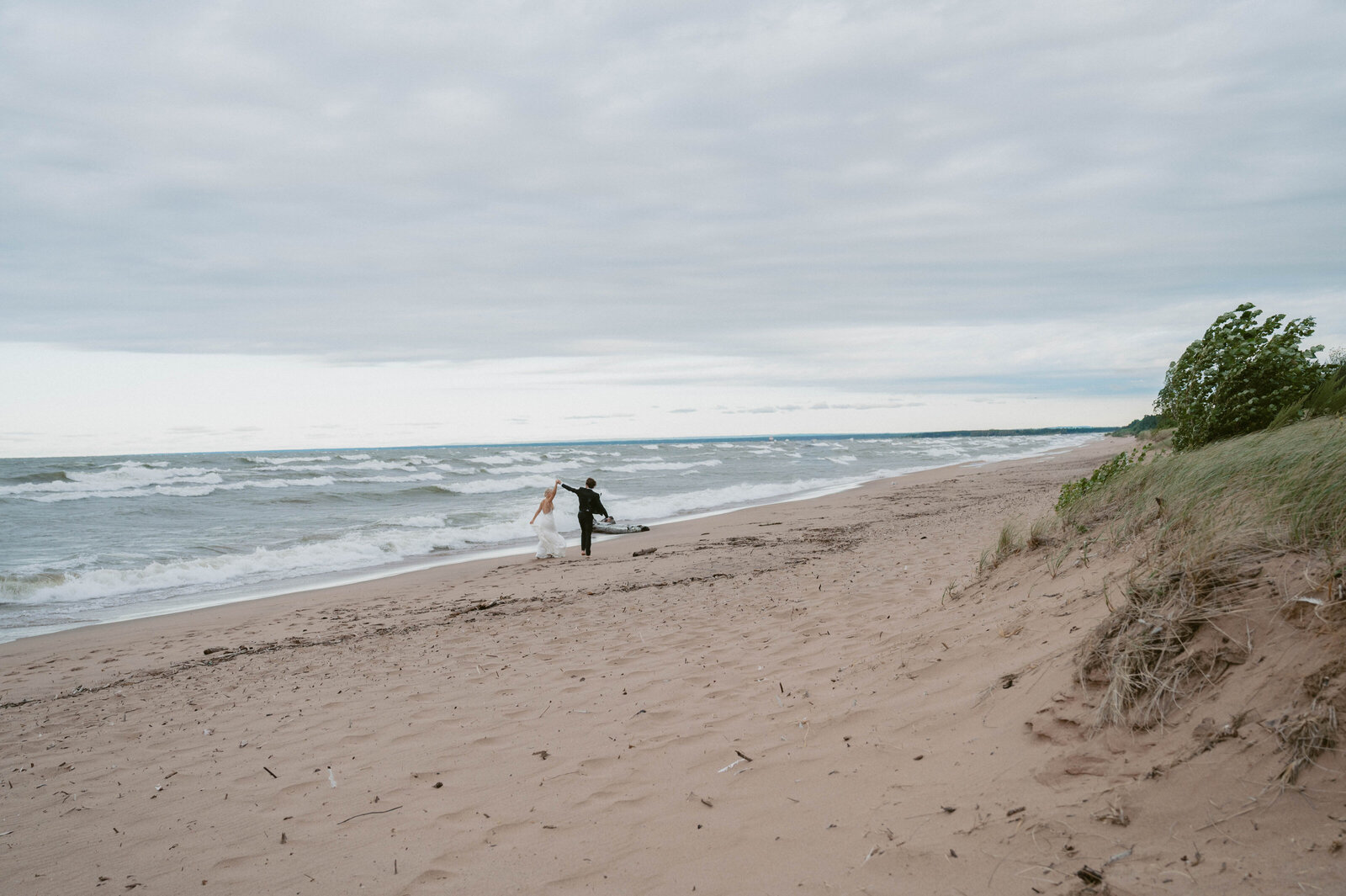 elopement couple ran on the beach of Lake Superior