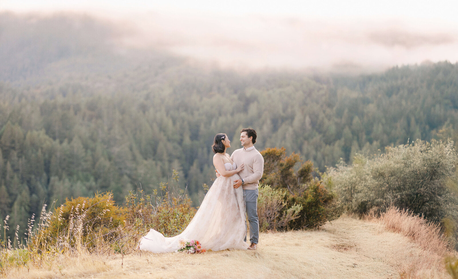 Couple on a cliffside posing for san francisco maternity photographer