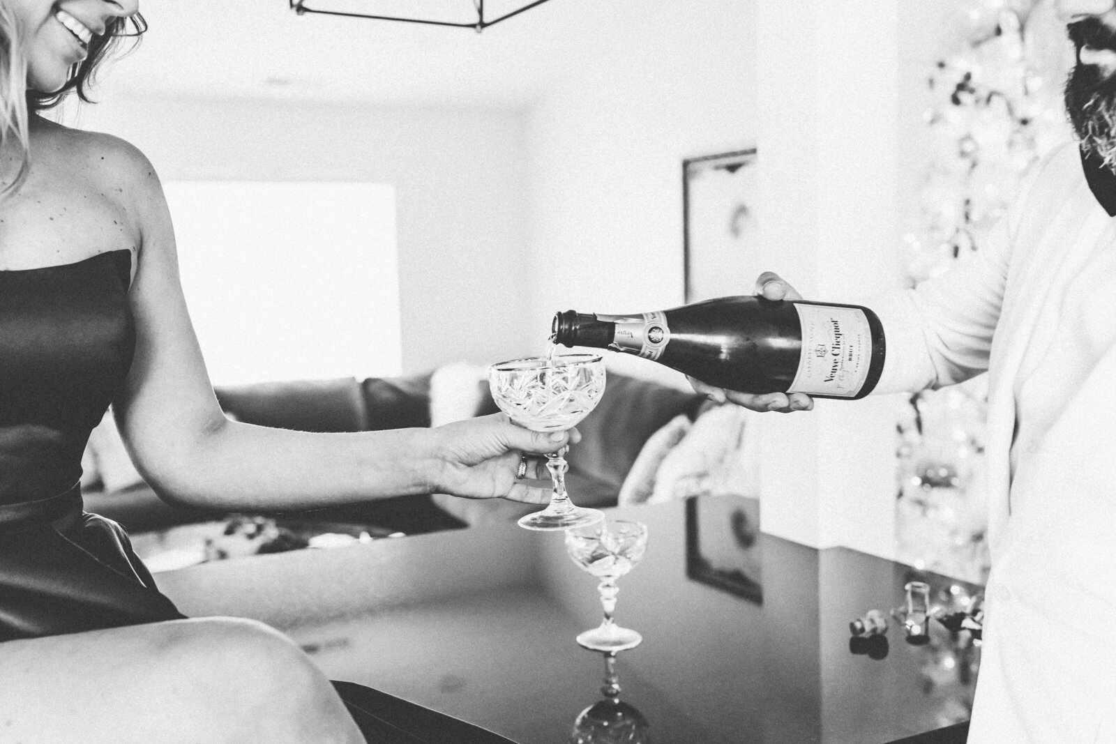 black and white picture of a champagne bottle being poured