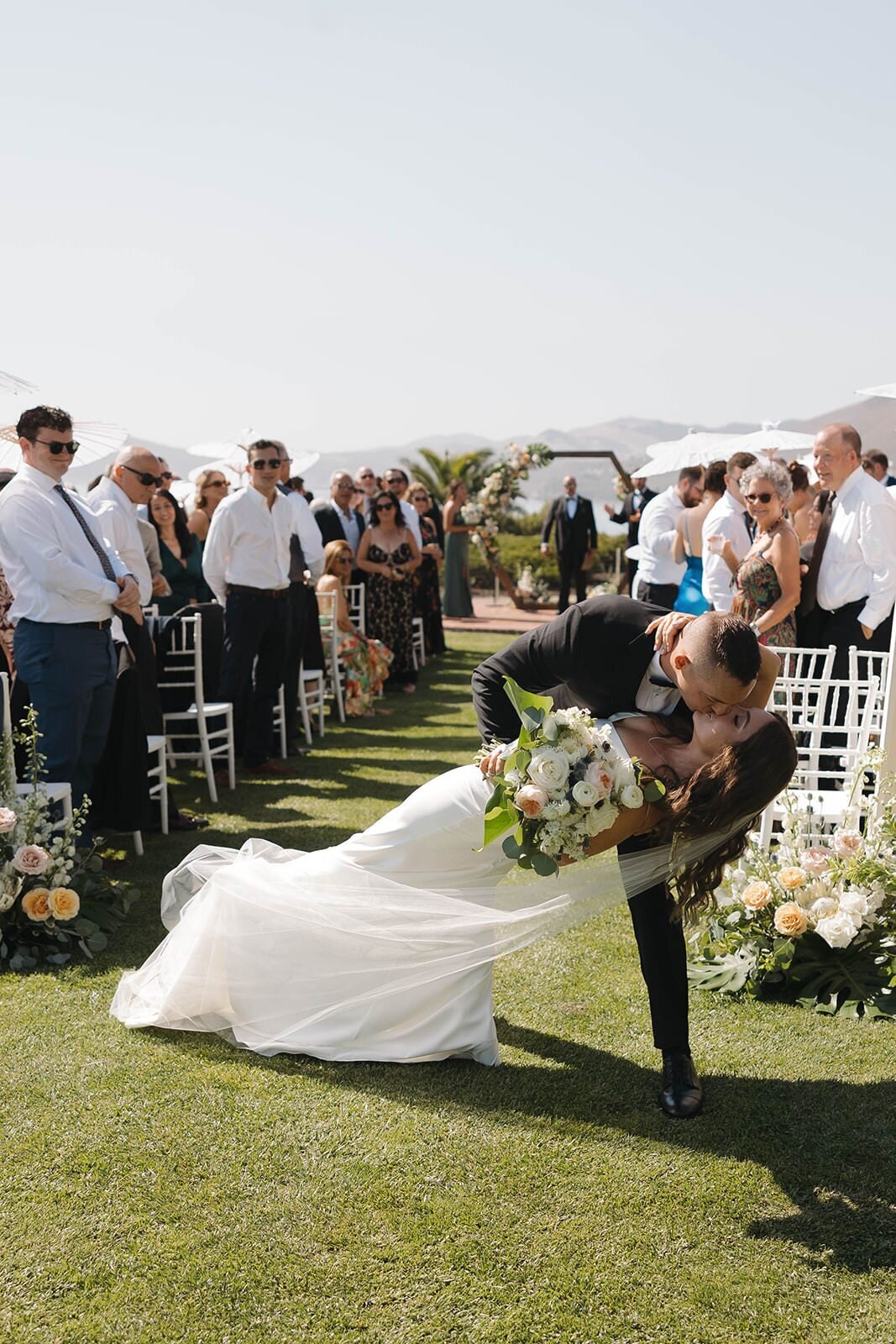 Groom dipping the bride for a kiss as they walk back up the aisle