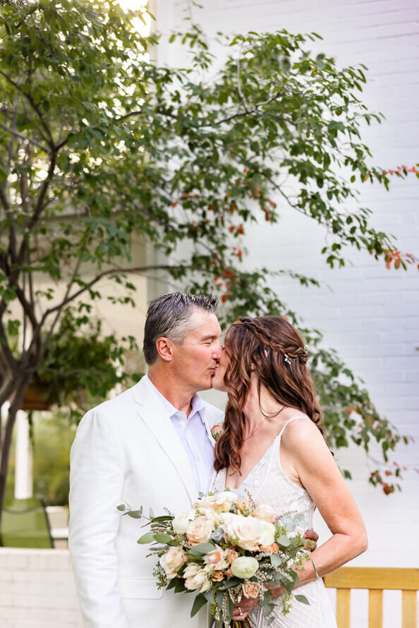 Couple in their wedding attire kisses at their Elopement at Chatfield Farms in Colorado.