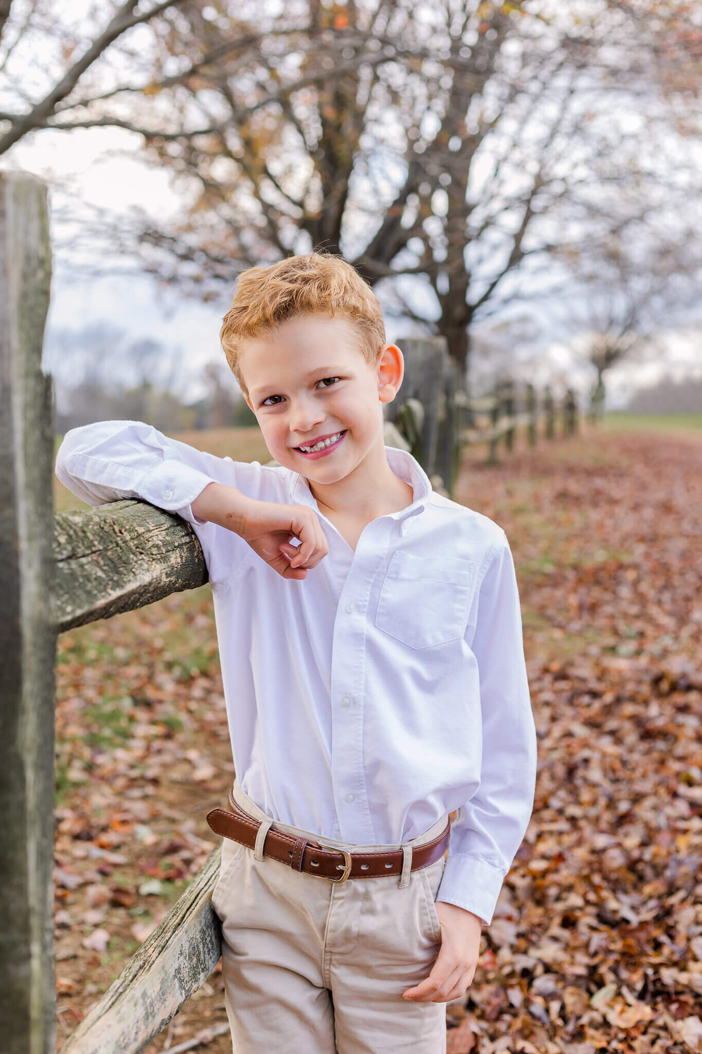 A young boy posing against a fence at a park in Burke, Virginia.