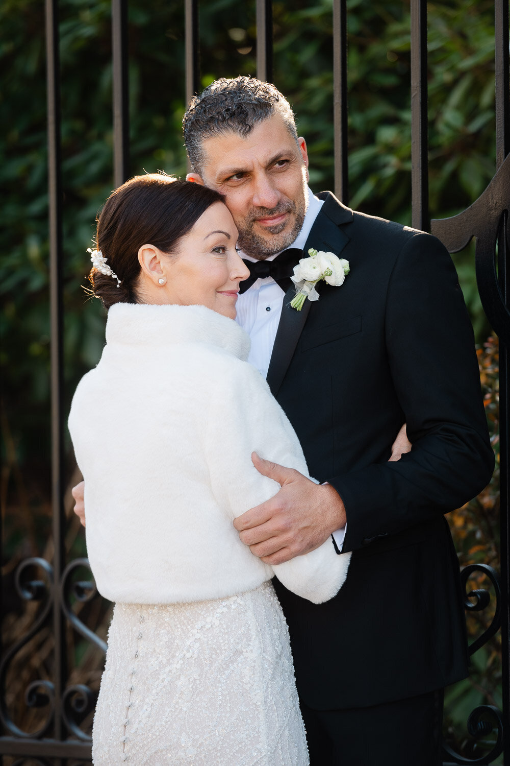 bride and groom hugging by gate