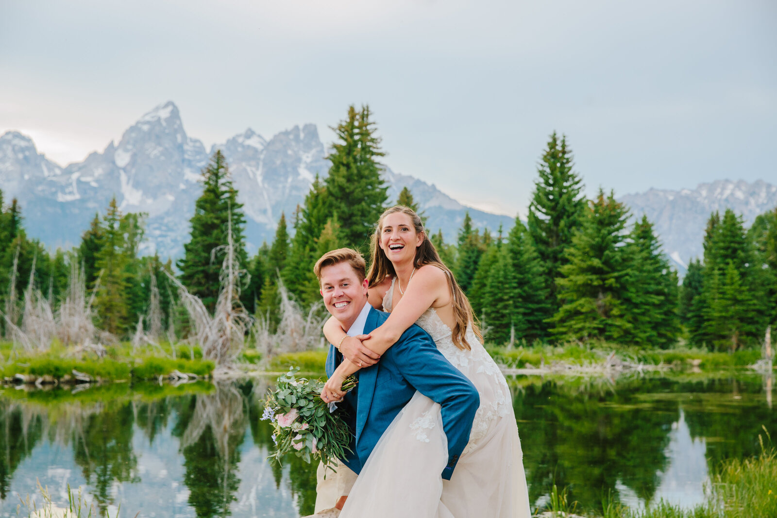 bride and groom celebrate with a piggy back after jackson hole elopement in grant teton national park