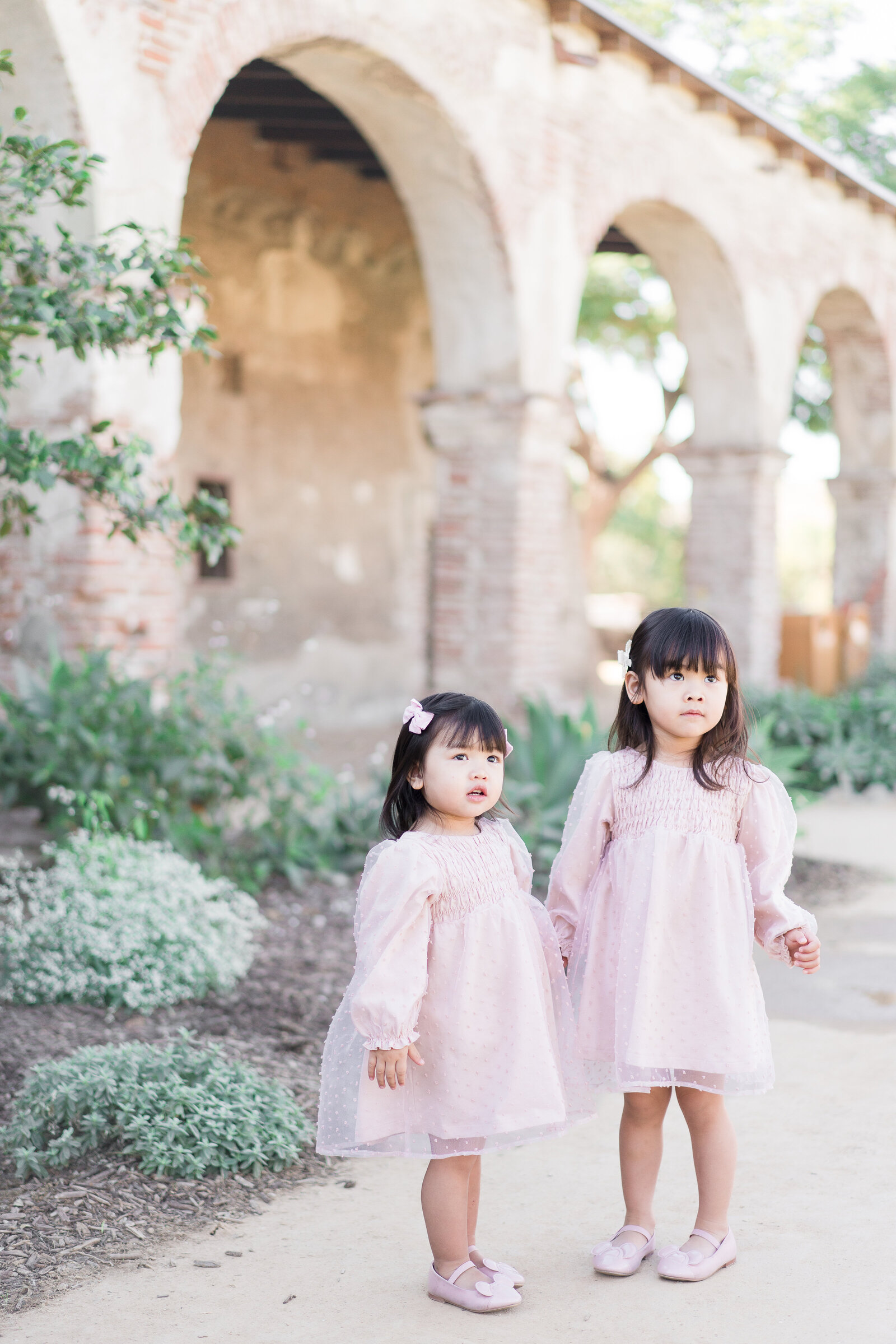 two cute sisters wearing pink dress