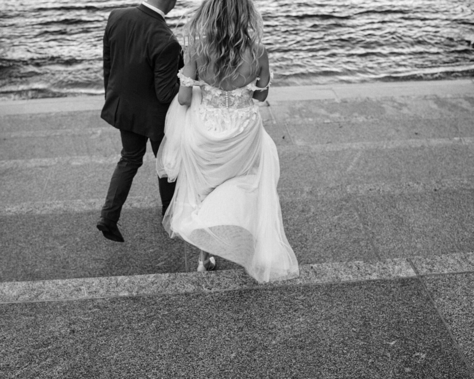 Wedding couple walking down steps to the water at Muir in Halifax.