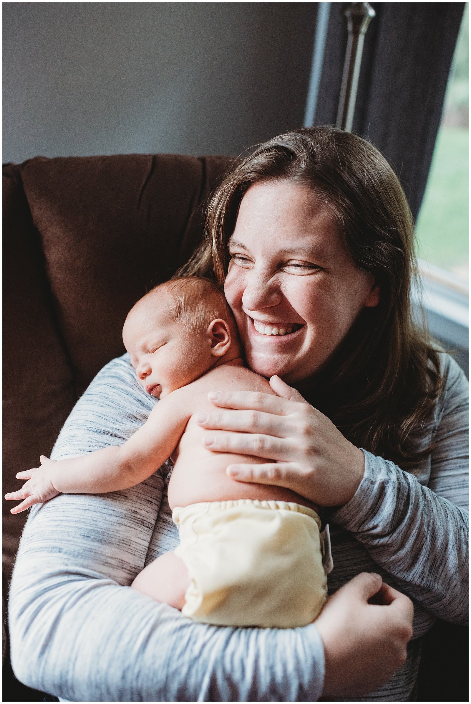 mom giggling holding newborn baby boy Emily Ann Photography Seattle Photographer