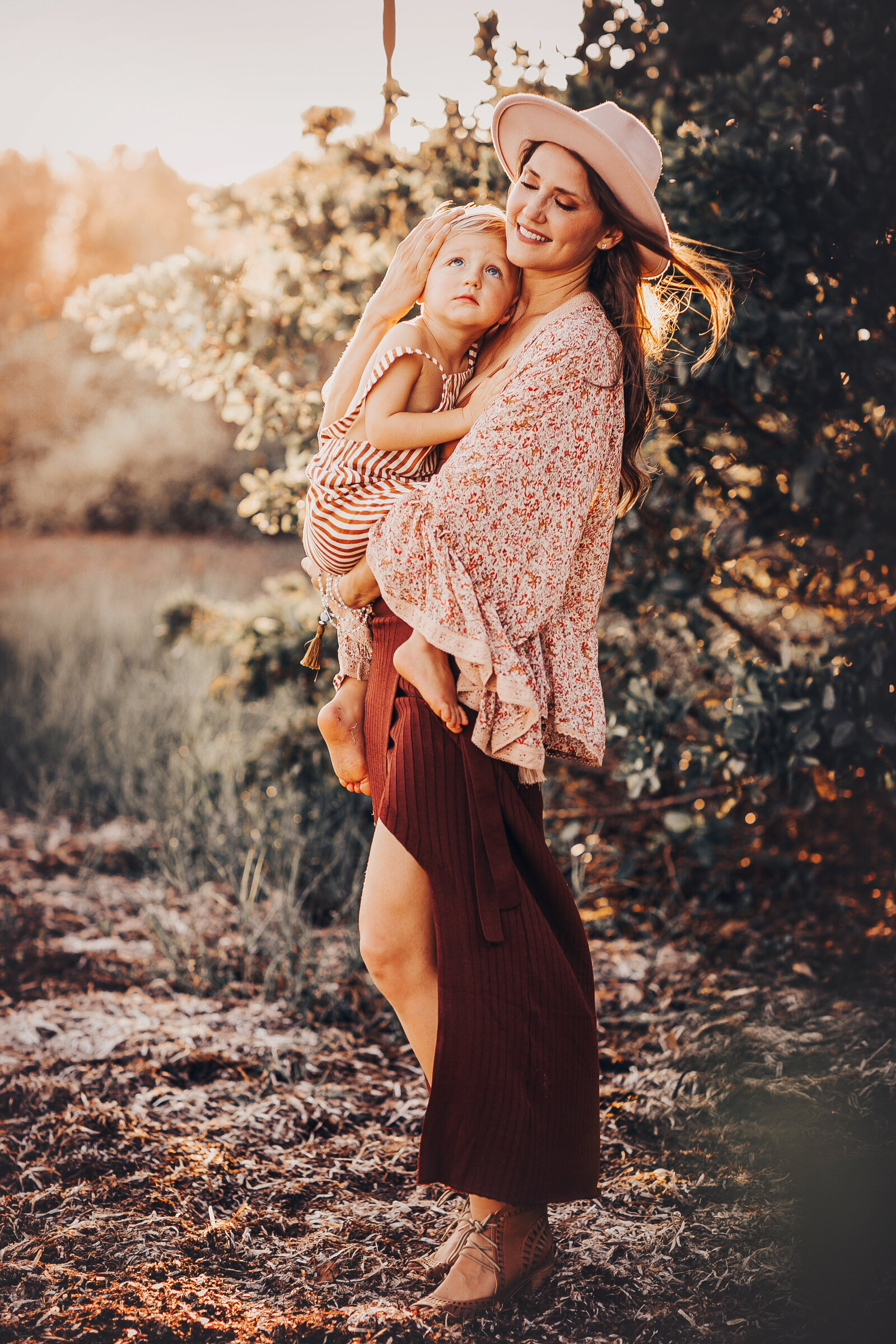 rust-skirt-mother-child-hat-trees-beach-wind