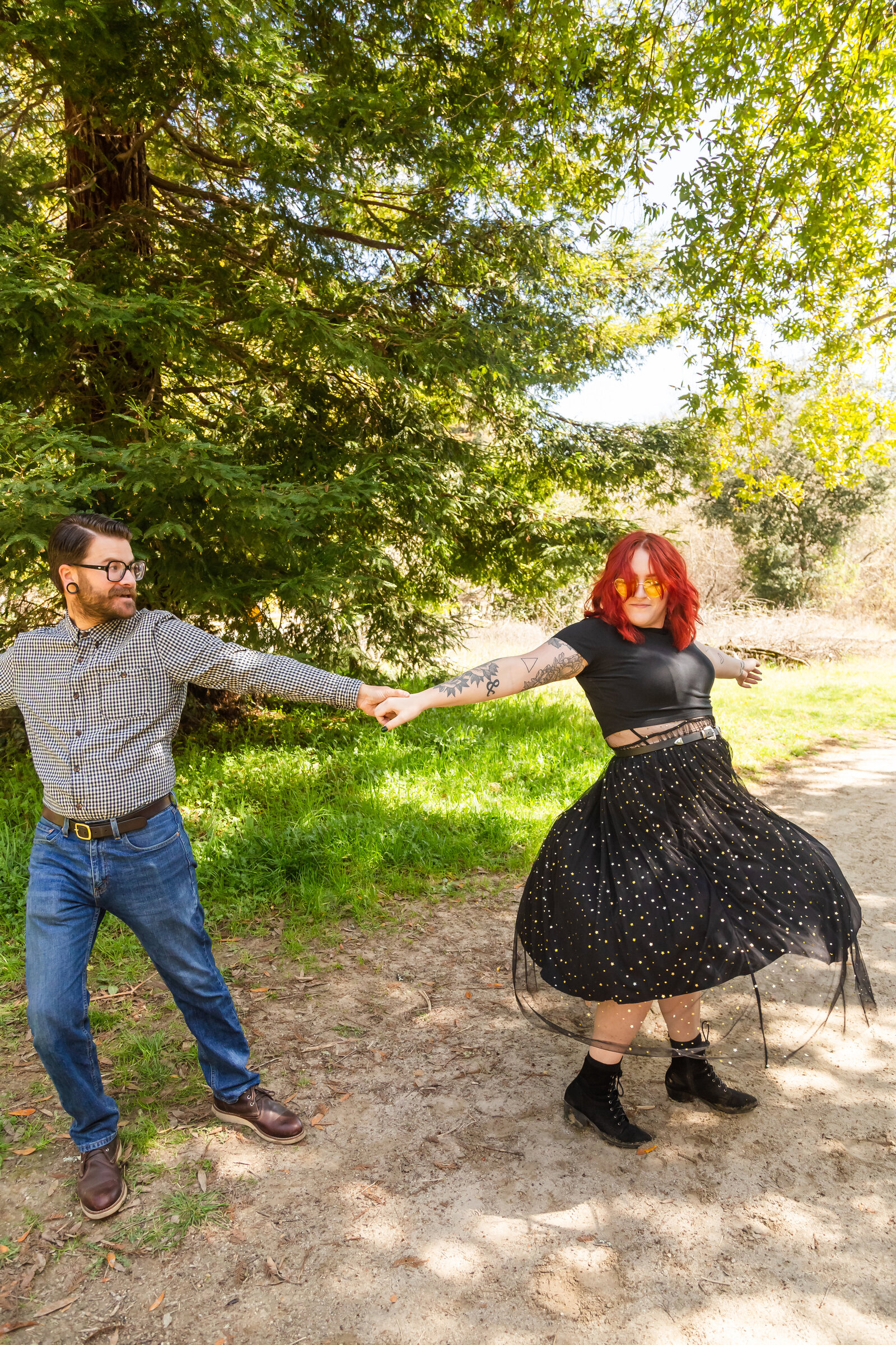 An tattooed engaged couple poses for photos in a redwood forest in Santa Cruz, Ca.